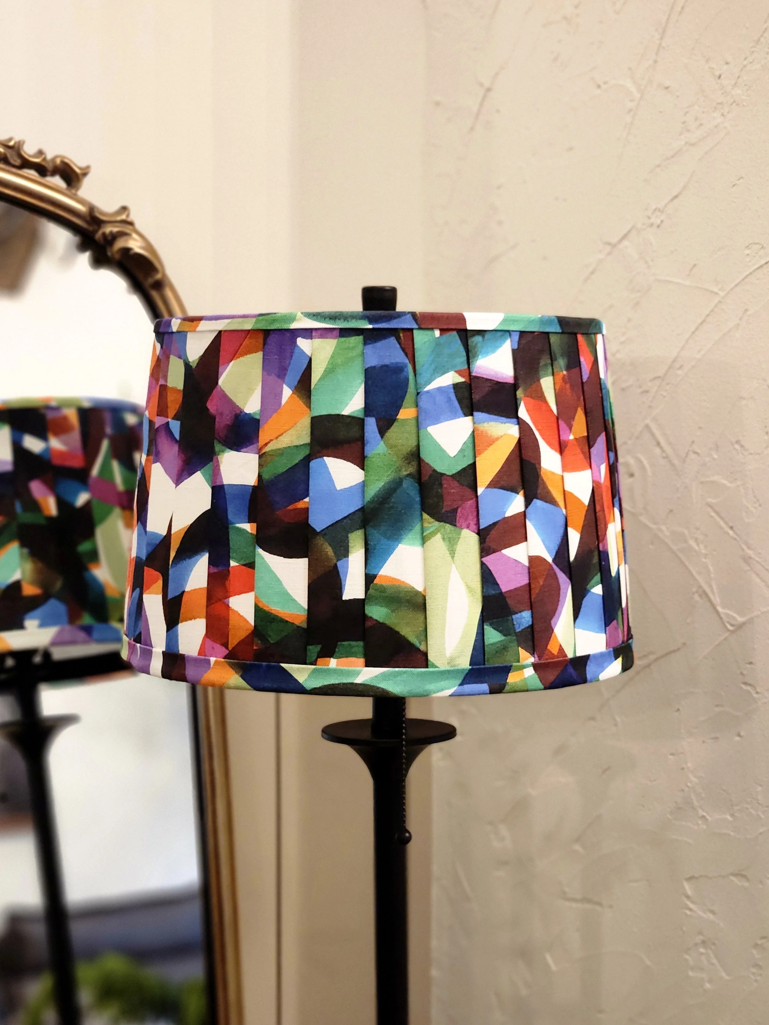 A vibrant lampshade with a colorful abstract pattern. The pleated design adds texture and visual interest to this statement piece.