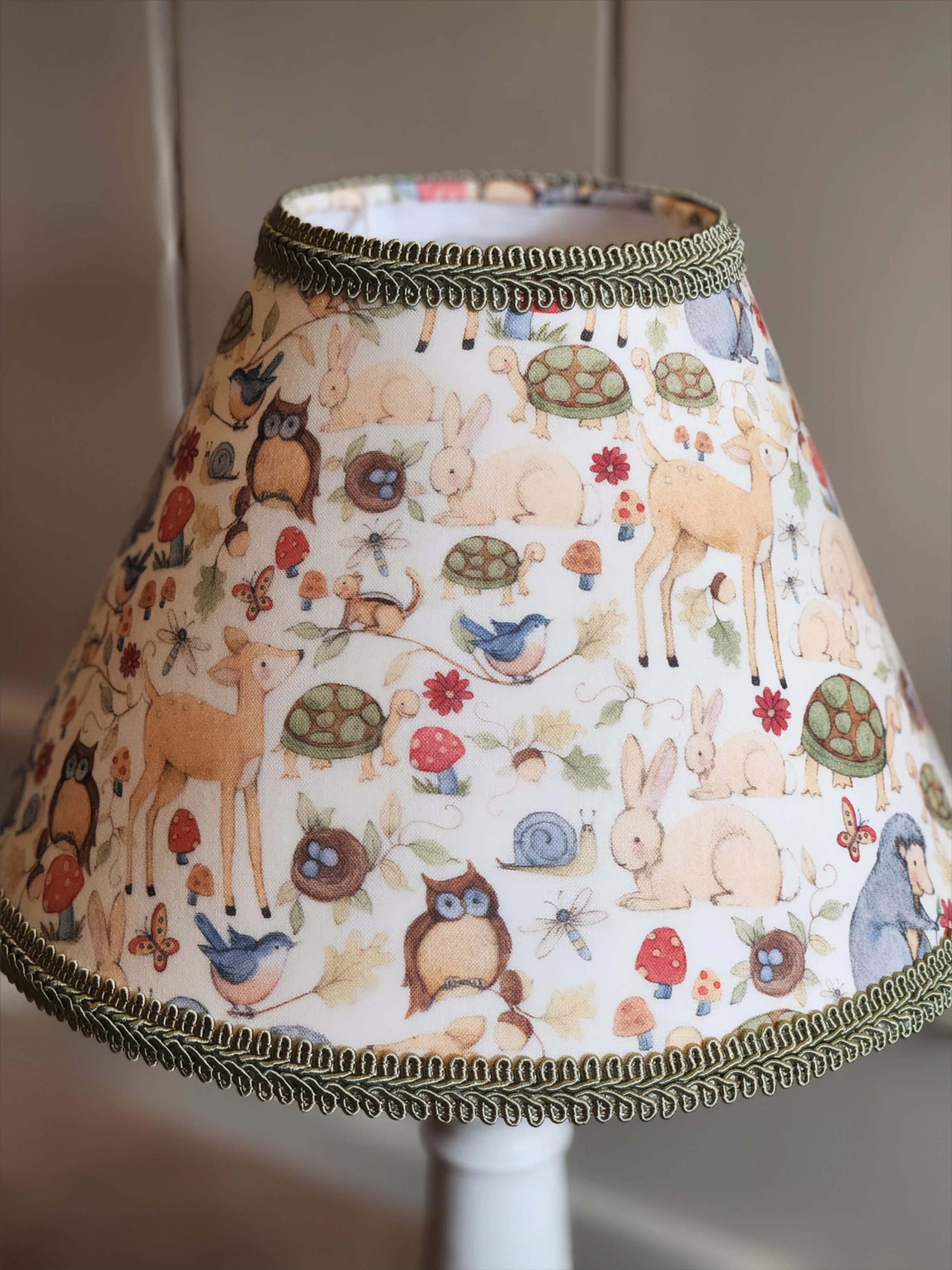 Decorative lampshade with woodland animal and nature pattern featuring rabbits, deer, owls, turtles, birds, mushrooms, flowers, and insects.