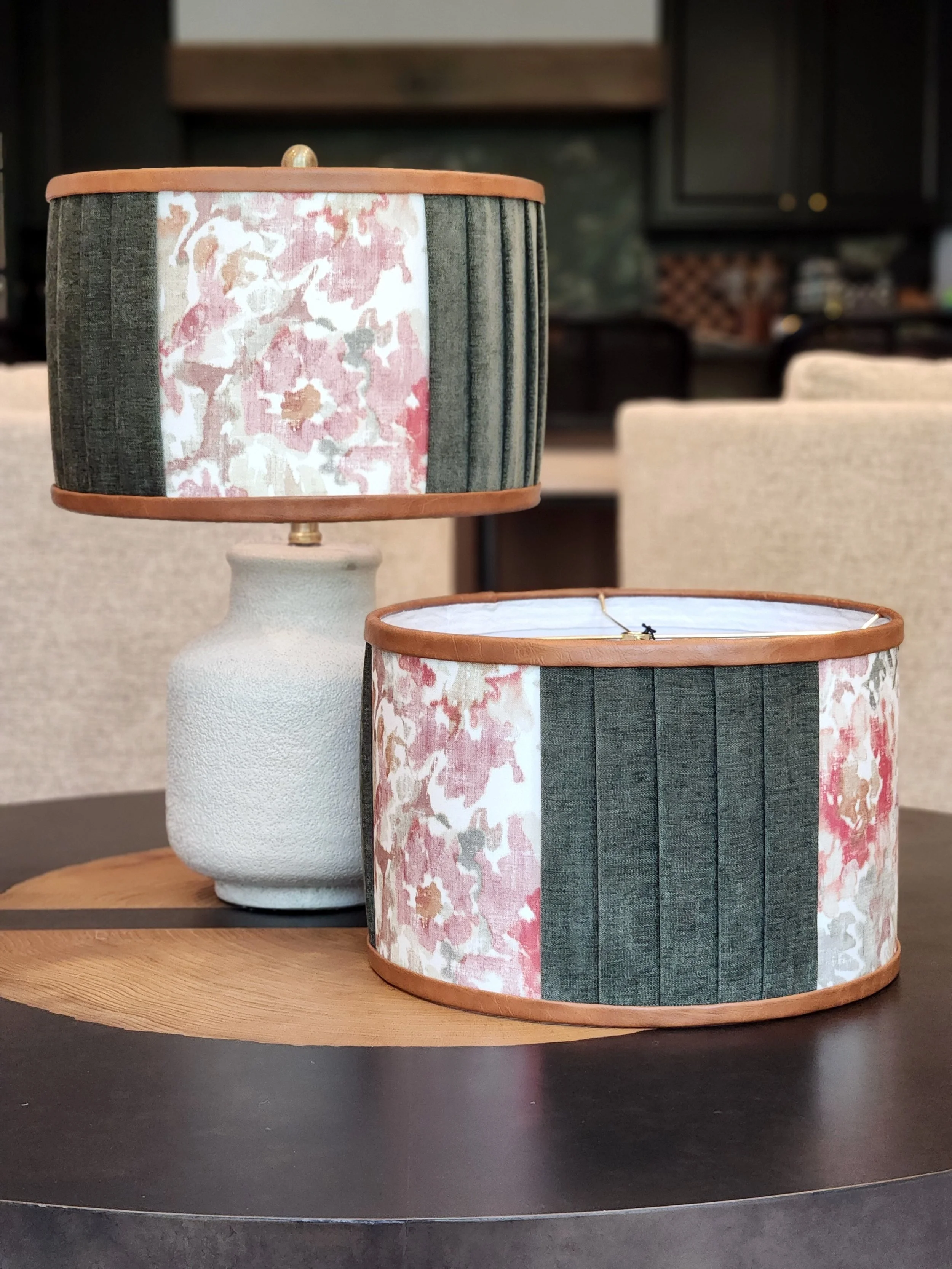 Decorative table lamp with floral fabric lampshade, placed on a wooden table.
