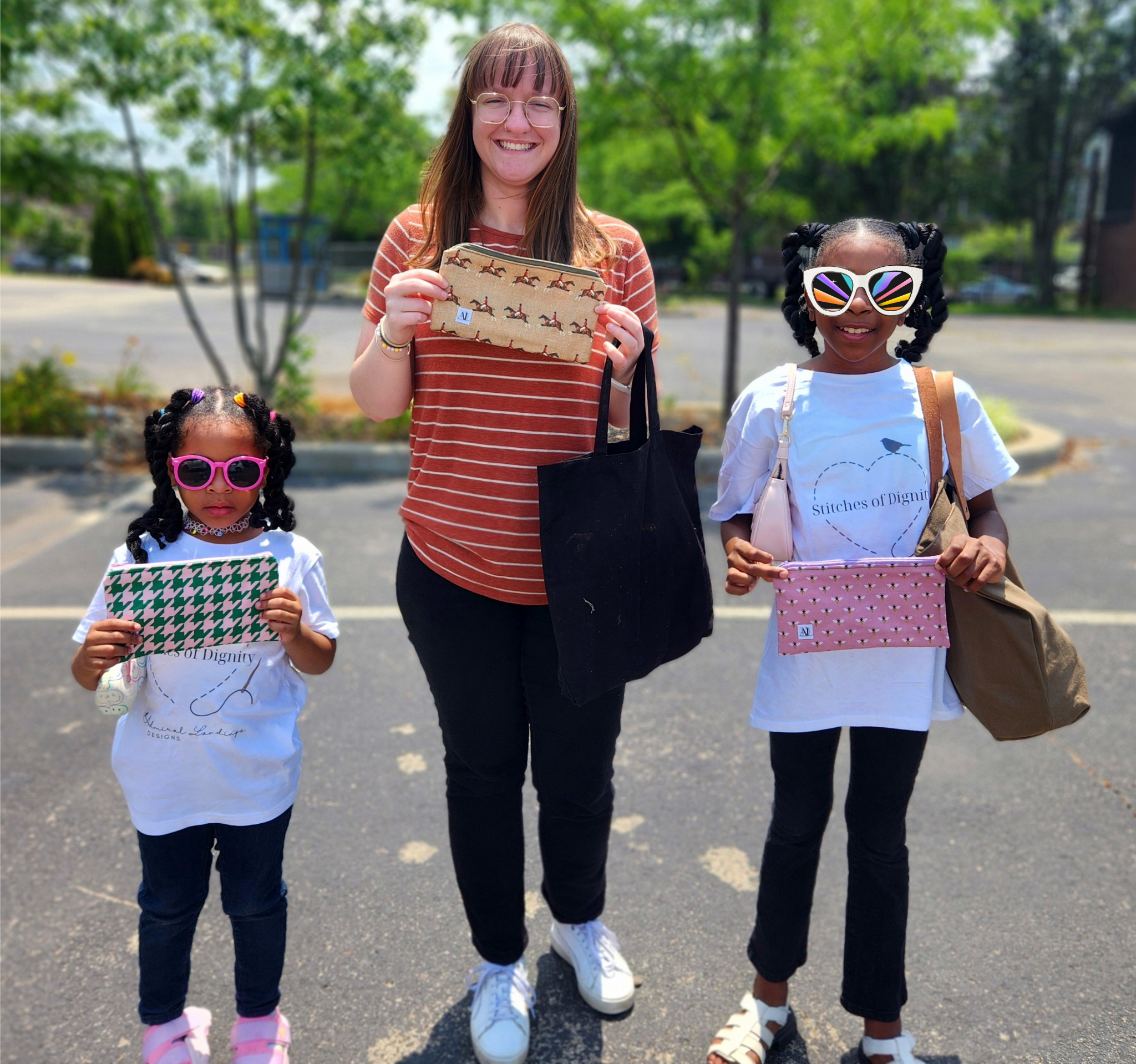 Three people outdoors holding patterned pouches and bags, with trees in the background.