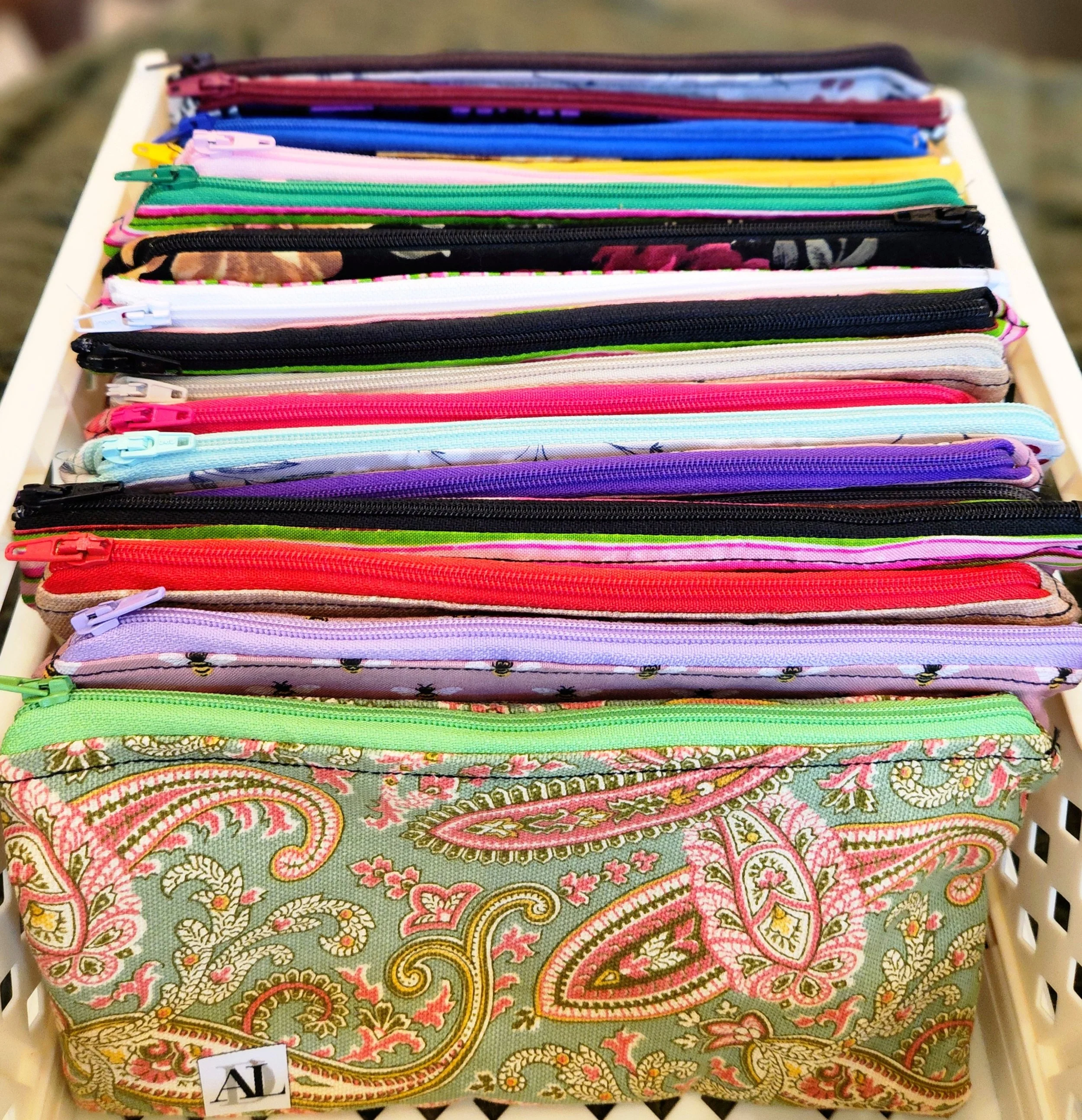 Assorted colorful zippered pouches in a storage basket
