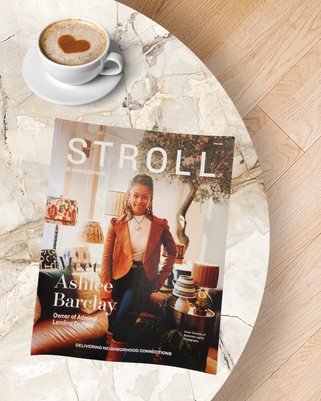 Magazine titled 'Stroll' on a marble table next to a cup of coffee with heart-shaped latte art.