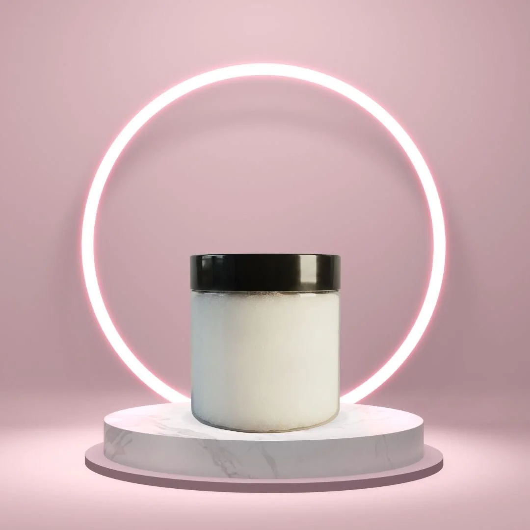 Thick With It Rouge Glow body butter in a white jar on a round pedestal against a pink background.