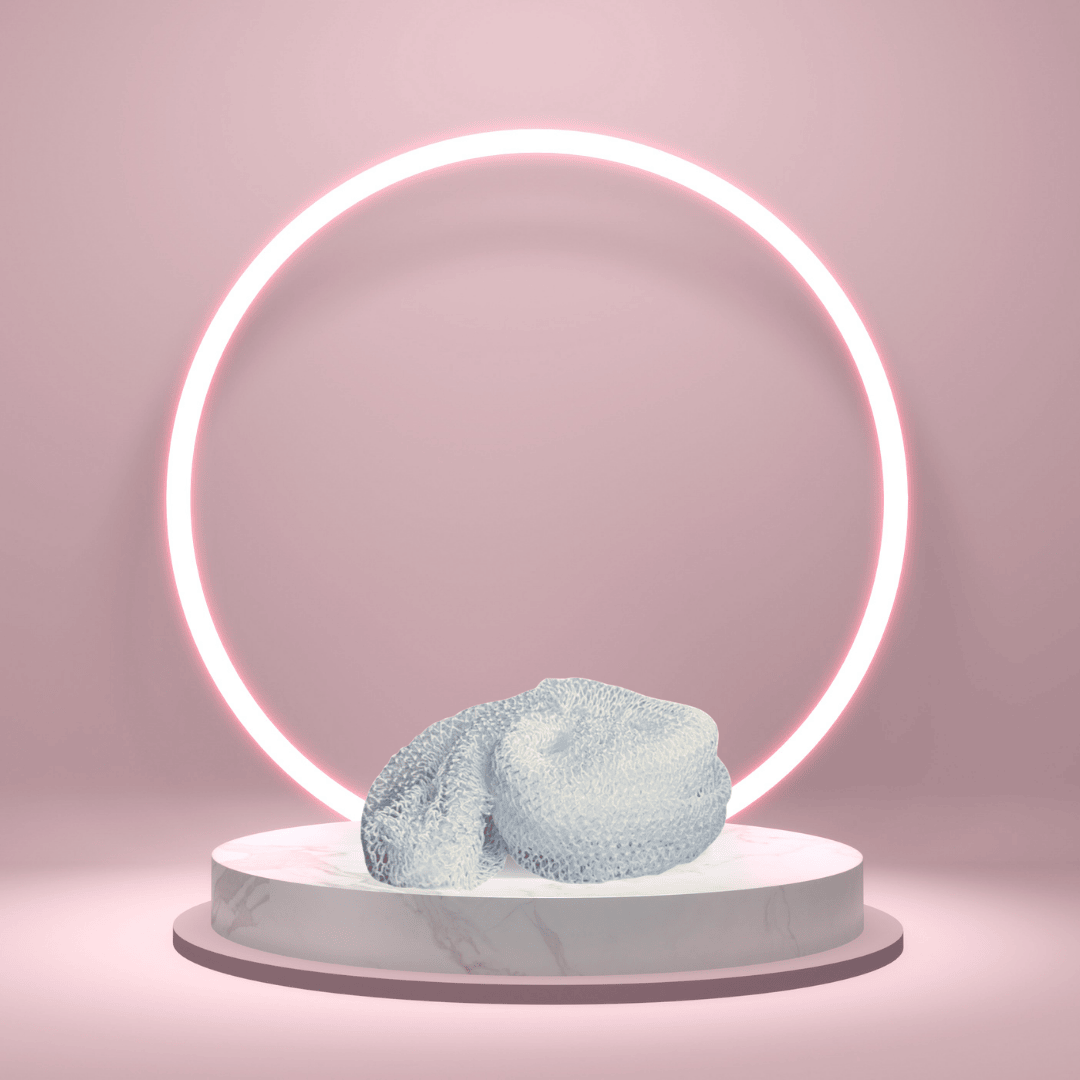 A polished hero image of the White Sapo Sponge from The White Line by Mama Aswan styled on a pink pedestal with a glowing ring backdrop for a clean, modern product presentation.