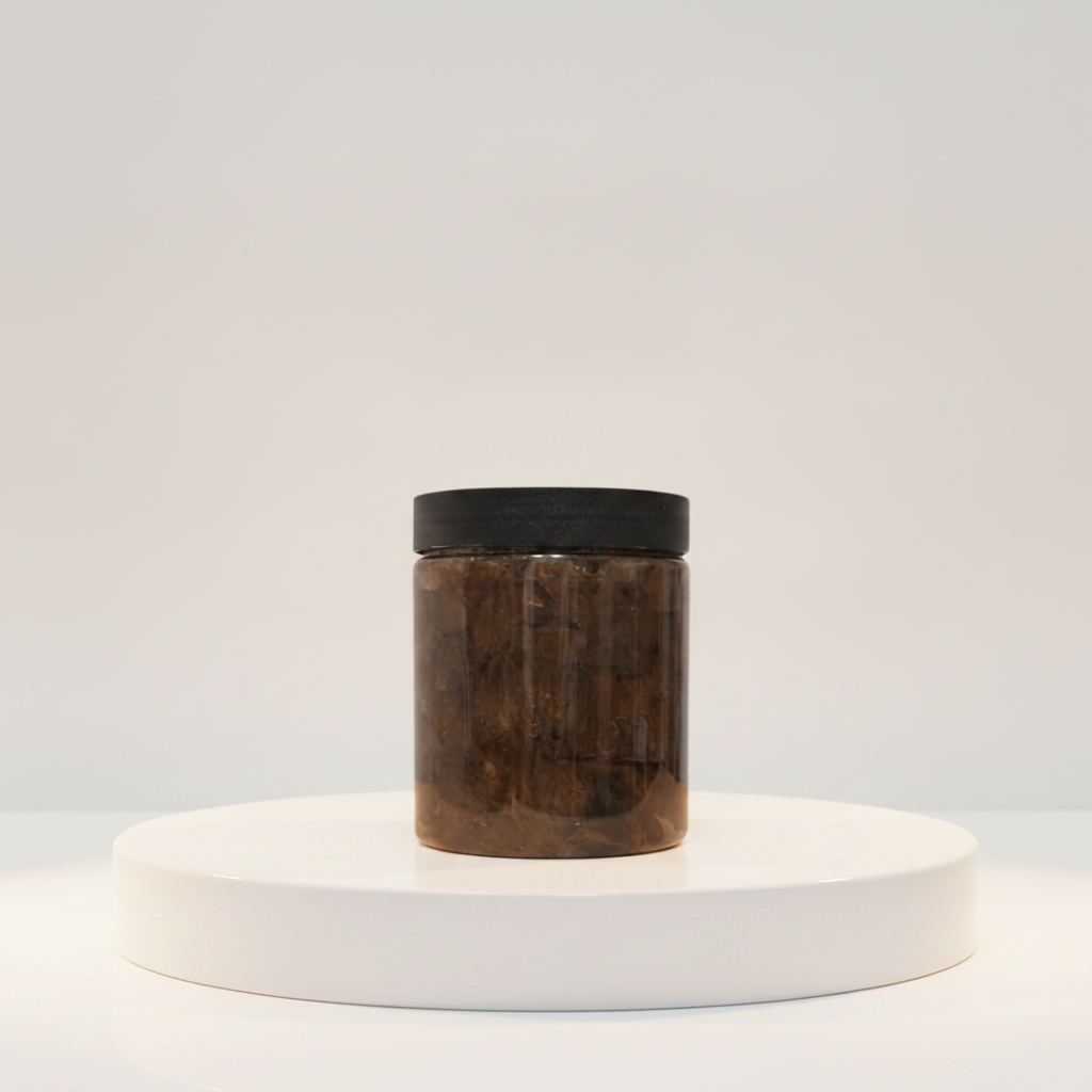 8 oz Raw African Black Soap Paste jar displayed on a white pedestal against a soft neutral background.
