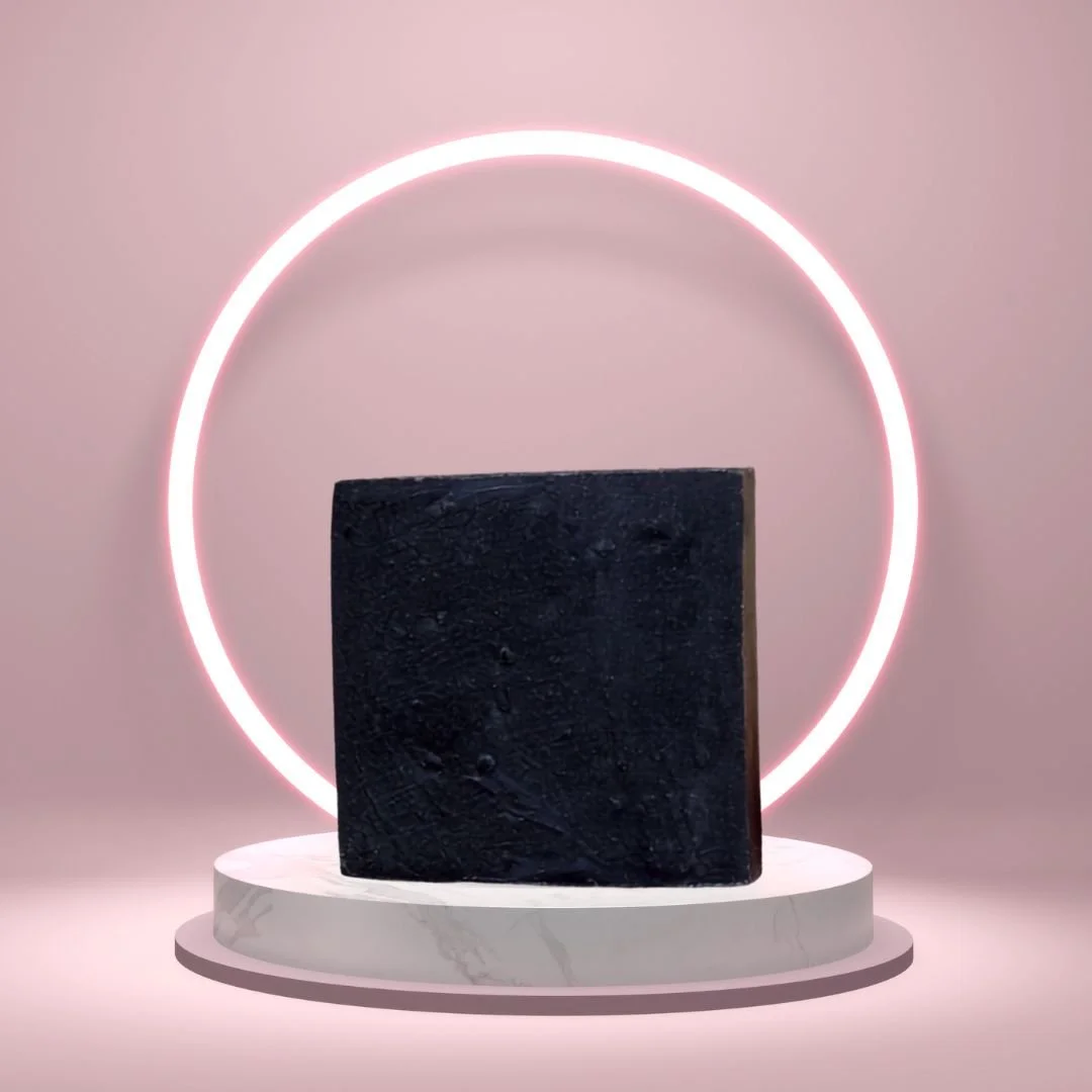Black Soap Bar on a white pedestal with a glowing pink circle background.