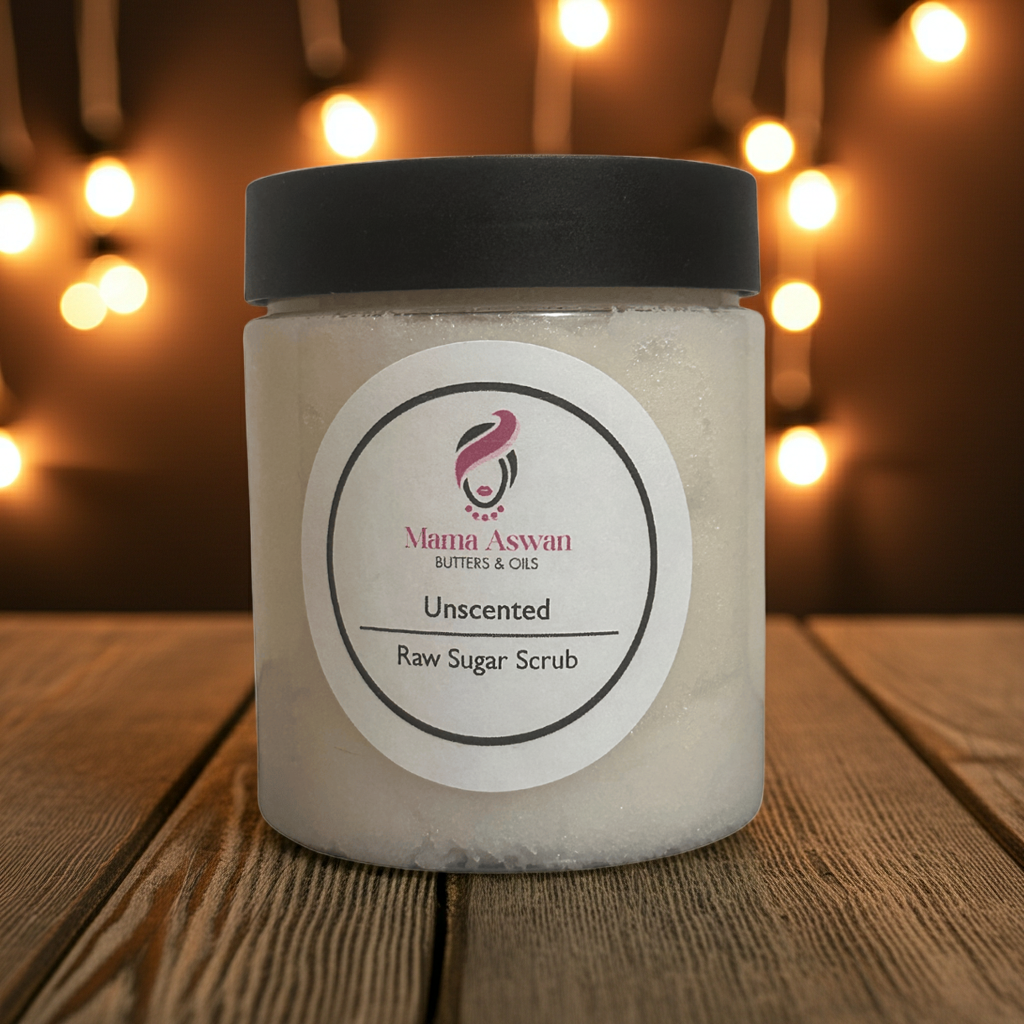 Mama Aswan Unscented Raw Sugar Scrub in a cozy, warm-lit scene with glowing string lights in the background.