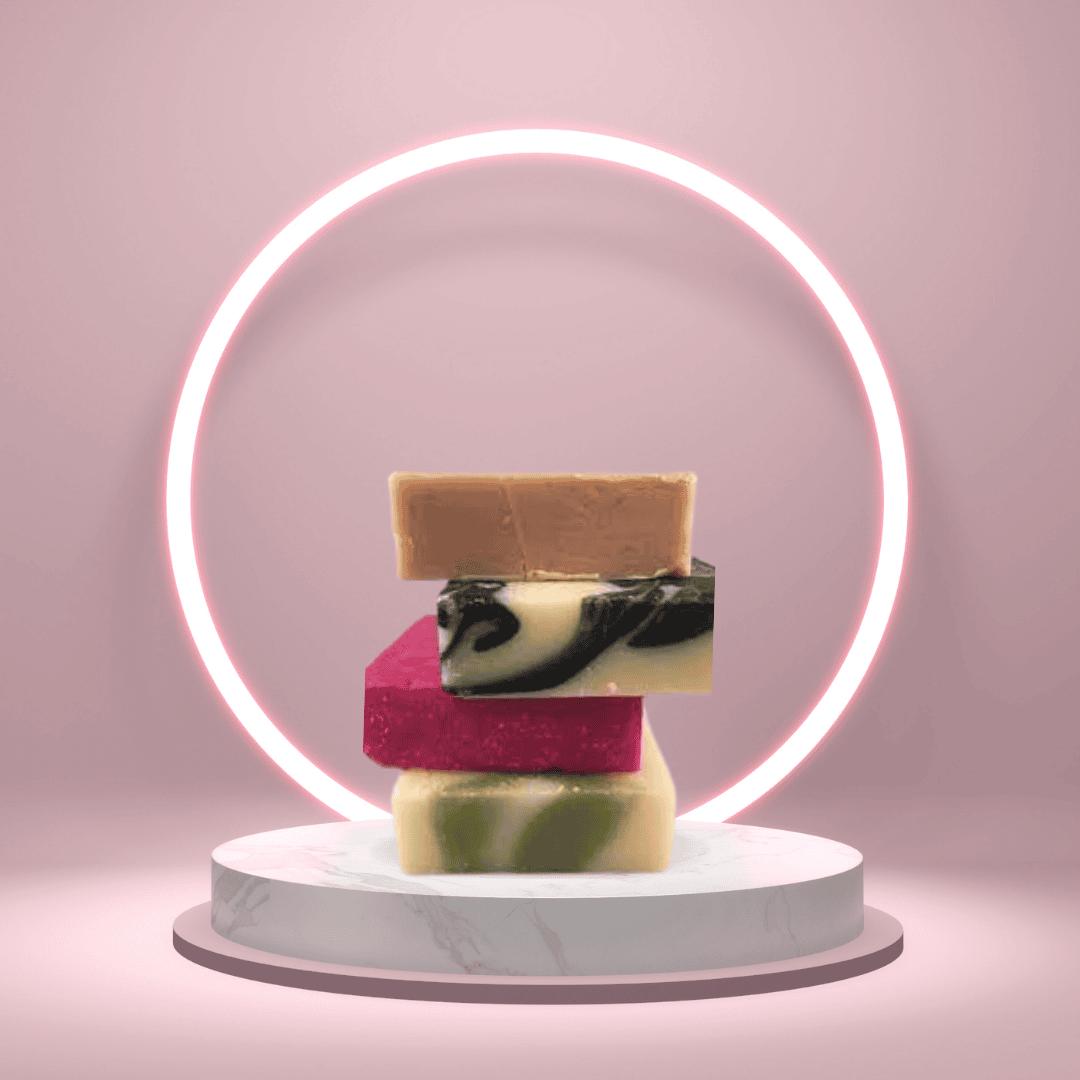 Stacked artisan soaps on a marble pedestal with pink neon ring light—Mama Aswan Butters & Oils natural bar soaps styled for luxury skincare lovers and conscious gift-givers