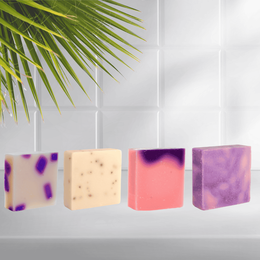 Vibrant purple and pink artisan soaps from Mama Aswan Butters & Oils displayed under tropical palm leaves—perfect for gifting, glowing skin, and fresh-smelling vibes.
