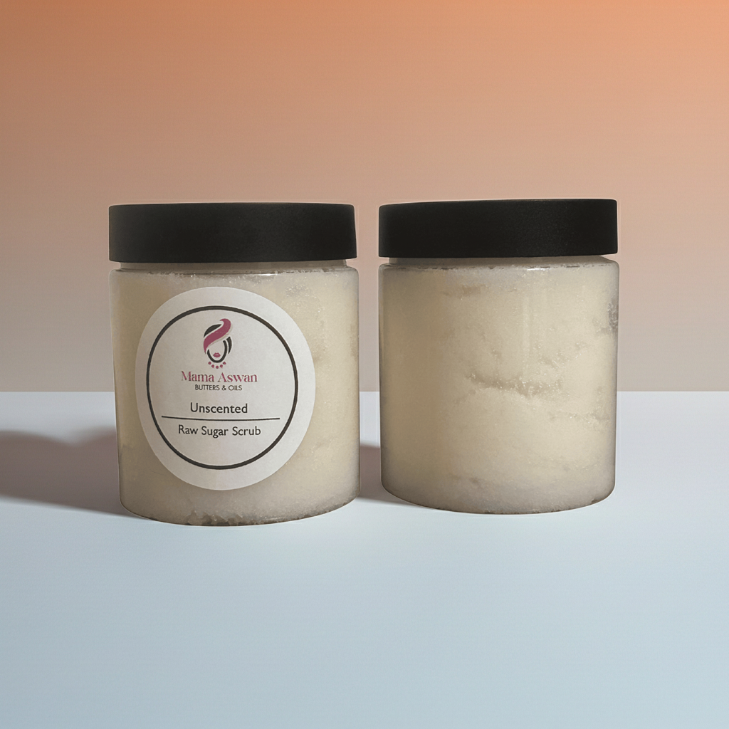 Two jars of Mama Aswan Unscented Raw Sugar Scrub against a warm gradient background.