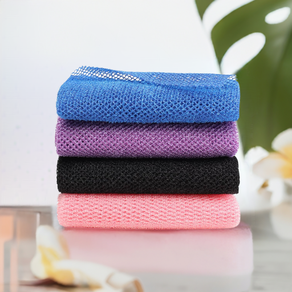 Neatly stacked blue, purple, black, and pink Long Body Scrubbers with tropical spa elements in the background, ideal for at-home exfoliating and shower rituals.
