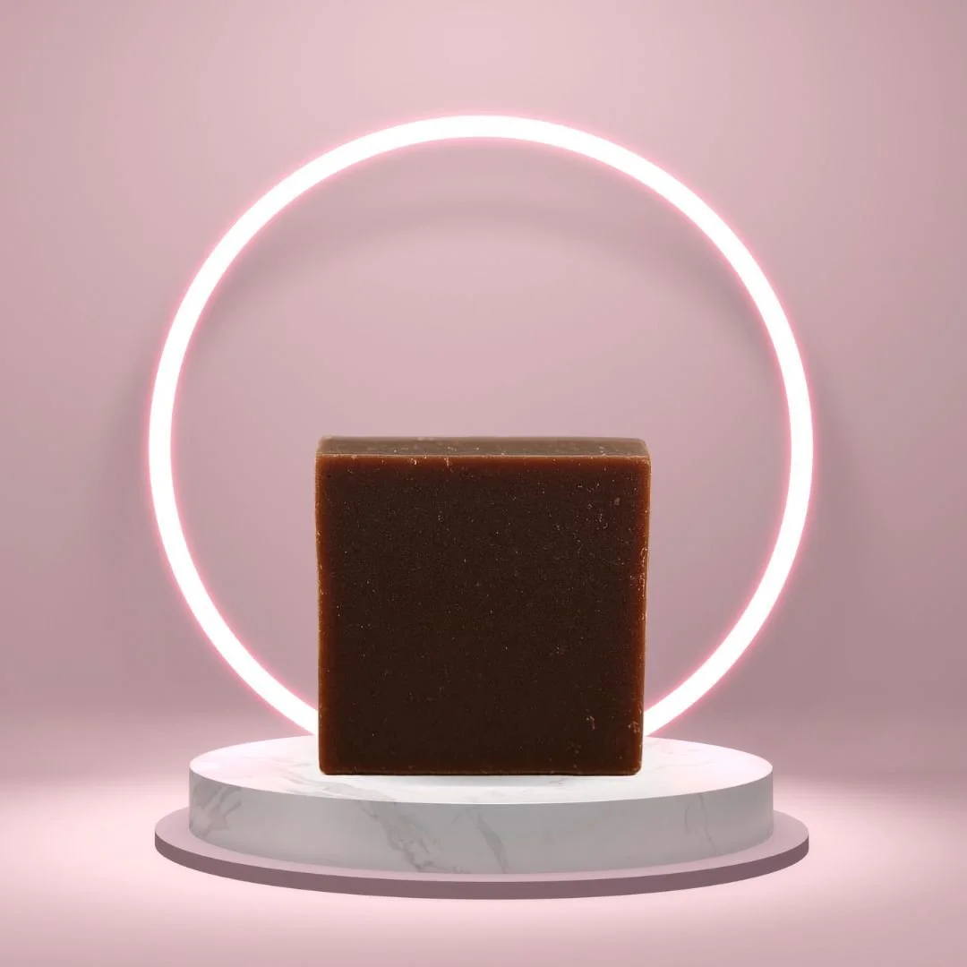 Moroccan Vanilla Goat’s Milk Soap Bar on a white pedestal with a glowing pink circle background.