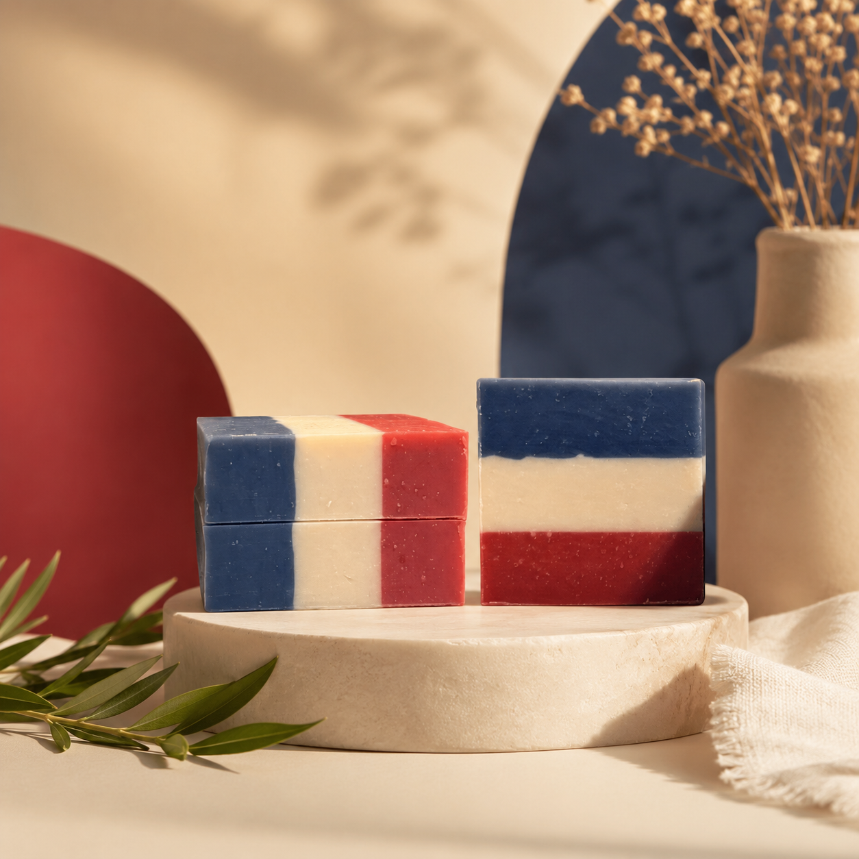 Several No Longer Bound soap bars arranged on a neutral pedestal with red and blue accents