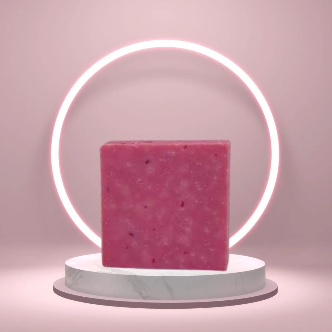 Spring Breeze Scrub Soap Bar on a white pedestal with a glowing pink circle background.