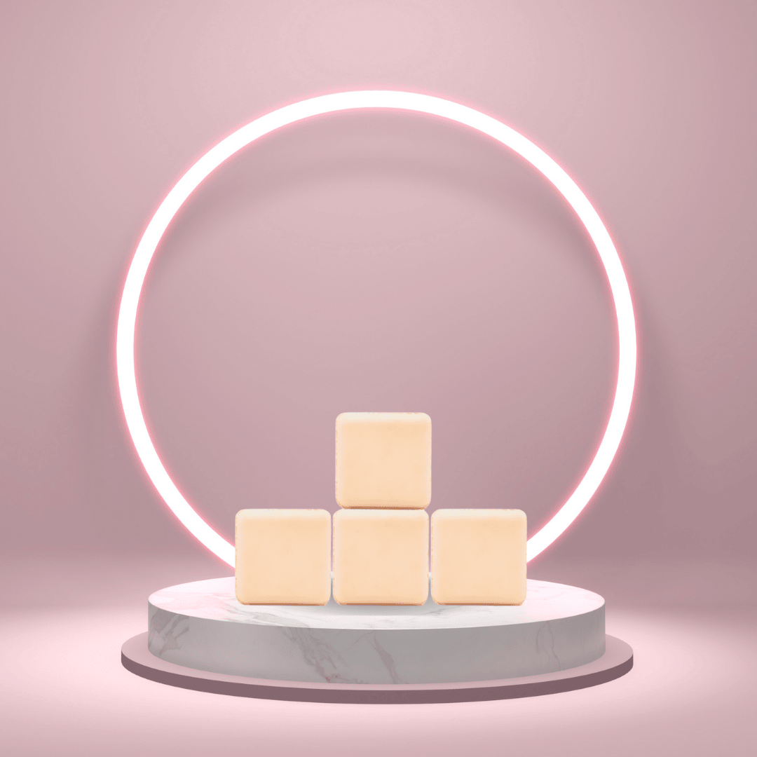 Four cream-colored Nag Champa shower steamers stacked on a marble pedestal with a glowing pink neon circle in the background.