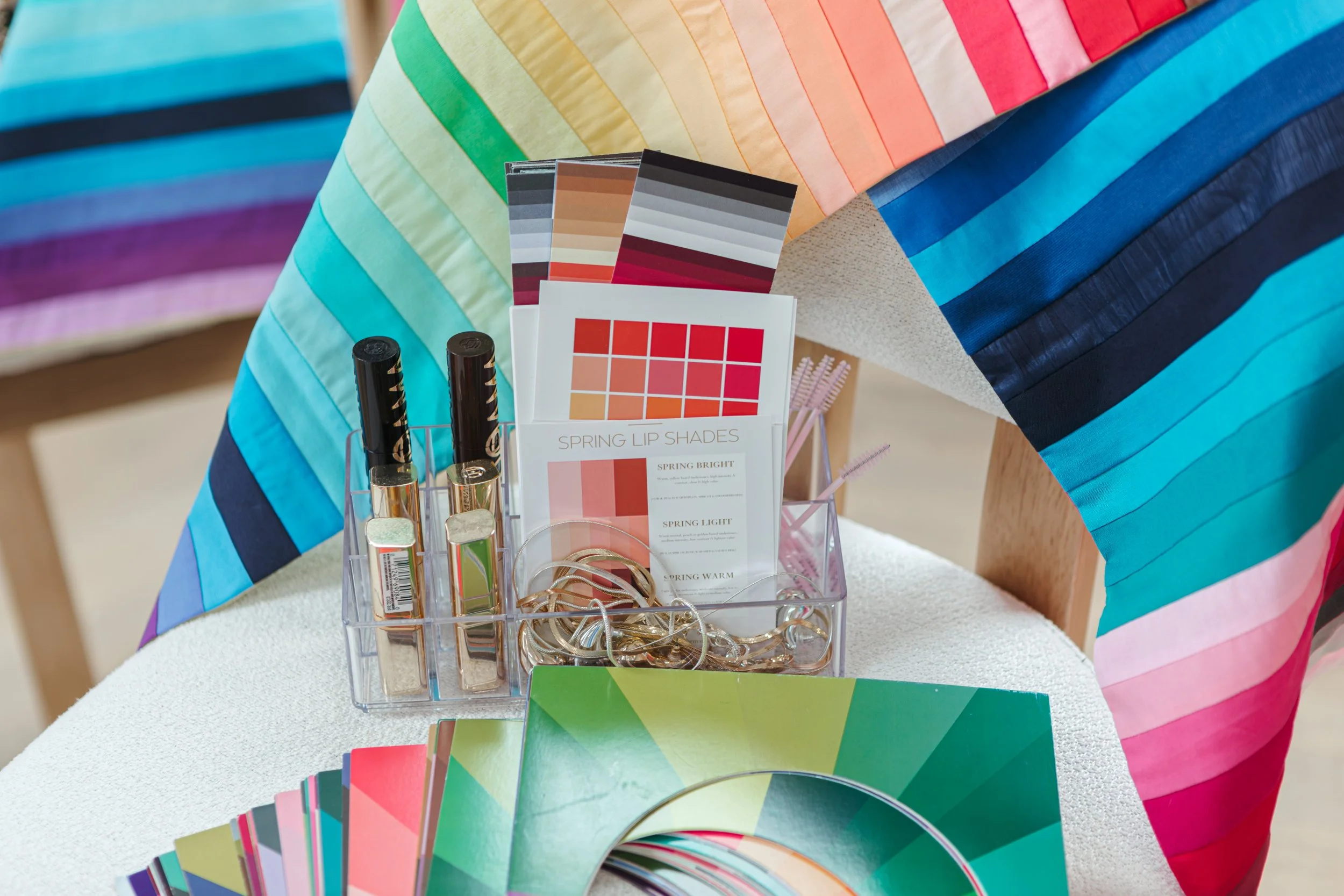 Colored fabric swatches in various shades, arranged in overlapping stacks.