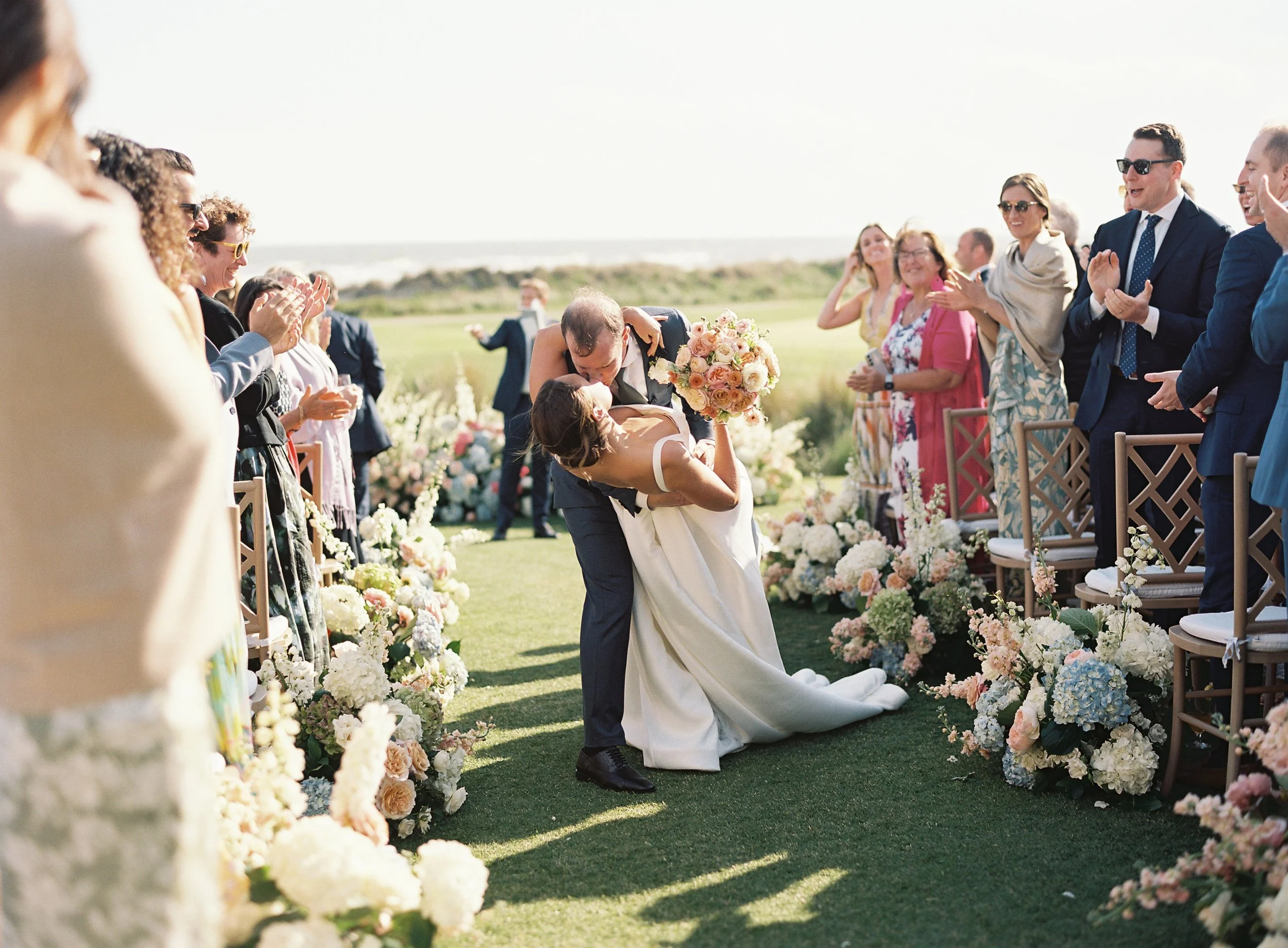 Couple shares first kiss after wedding ceremony on the ocean course on kiawah
