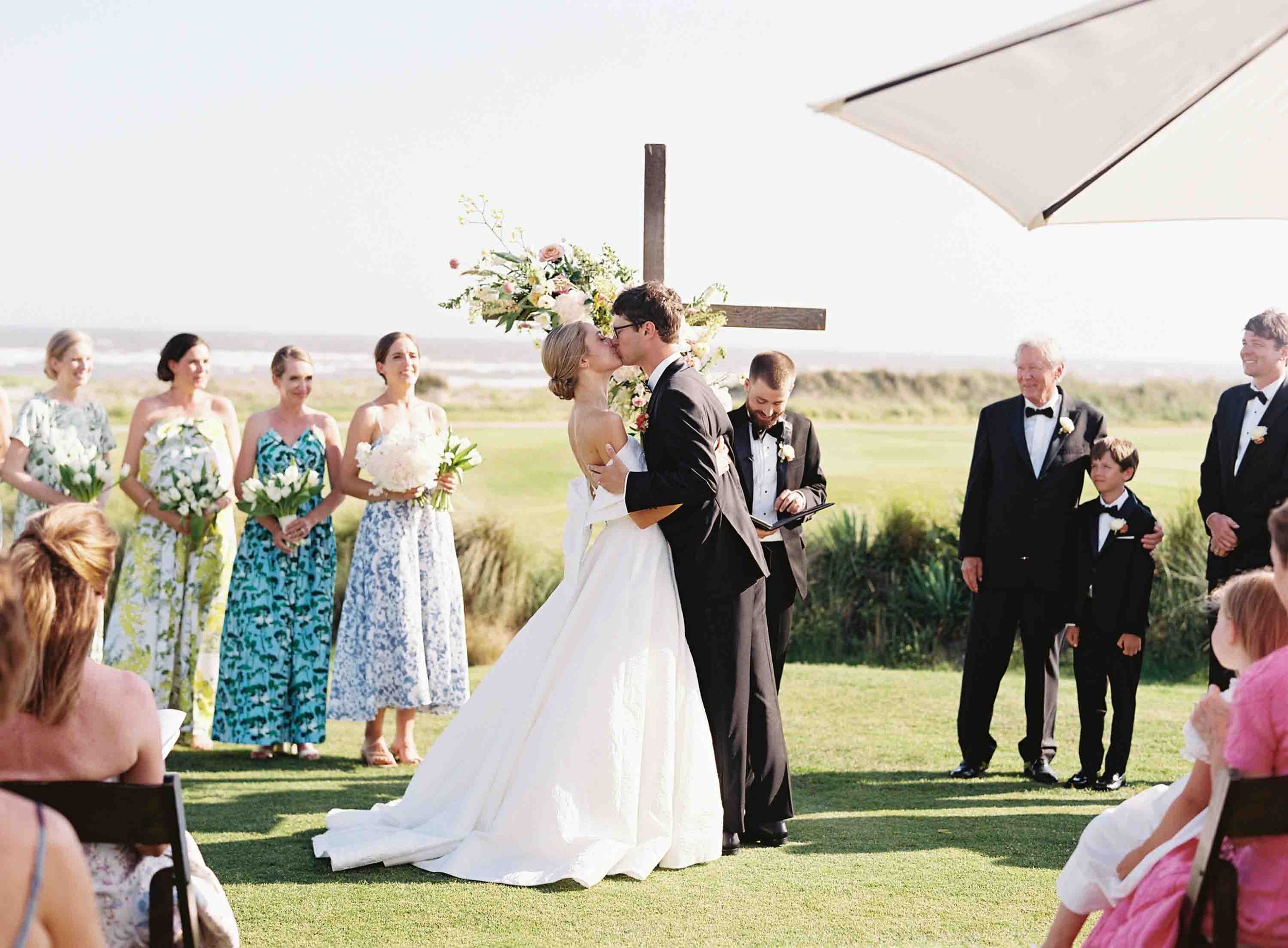 Bride and groom kissing during their outdoor ceremony at the Ocean Course on Kiawah Island