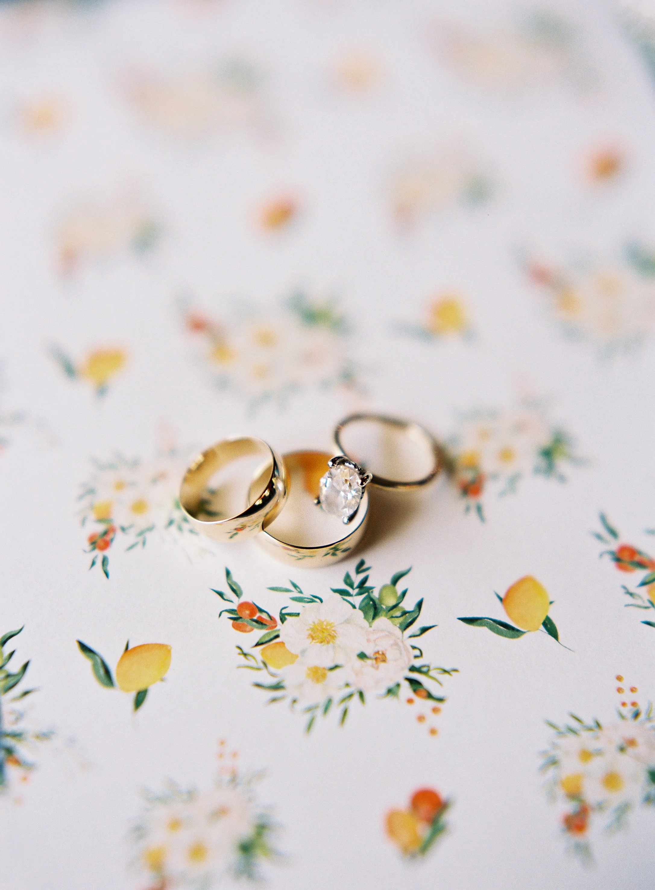 Wedding rings flat lay with floral paper at William Aiken House wedding in Charleston South Carolina