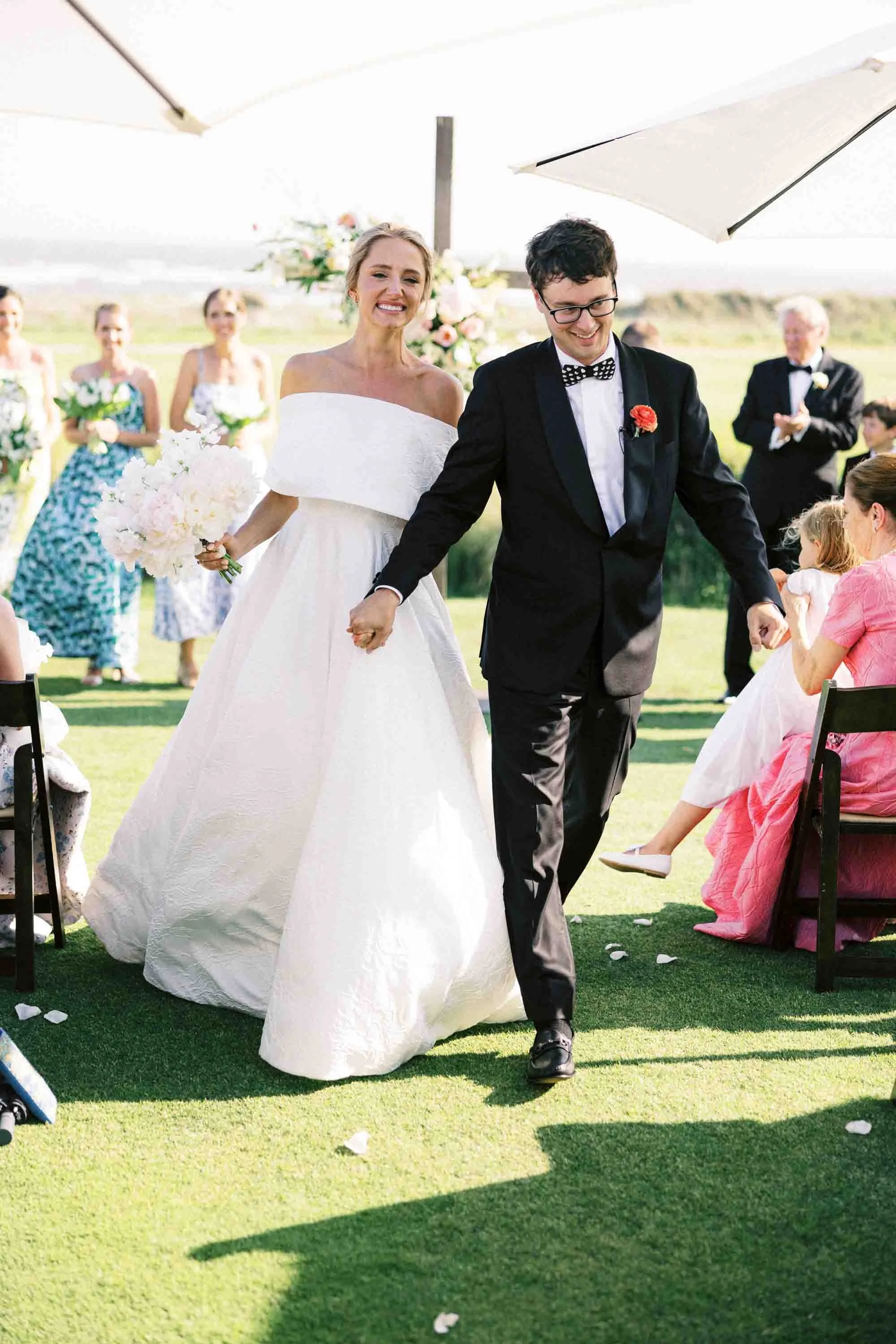 Bride and groom walking down the aisle together after their ceremony on the Ocean Course