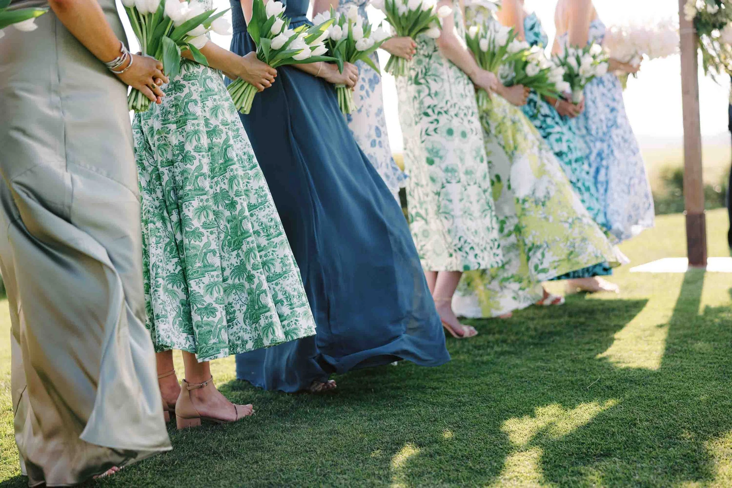 Bridesmaids in patterned dresses standing together during an outdoor wedding ceremony at Kiawah Island