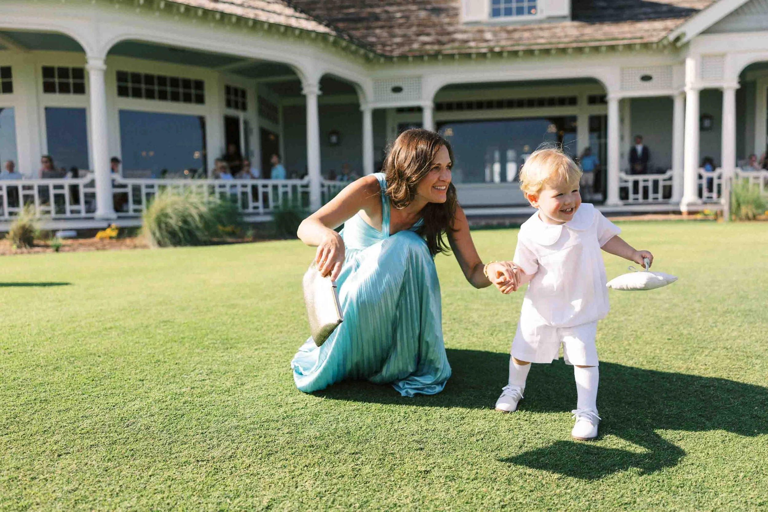 Mother and ring bearer sharing a candid moment on the lawn during a Kiawah Island wedding