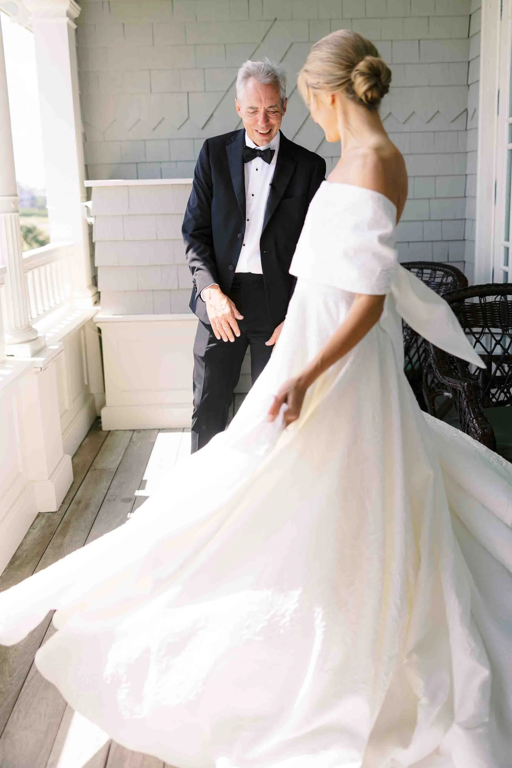 Bride twirling in her gown with her father on a balcony before the ceremony at Kiawah Island