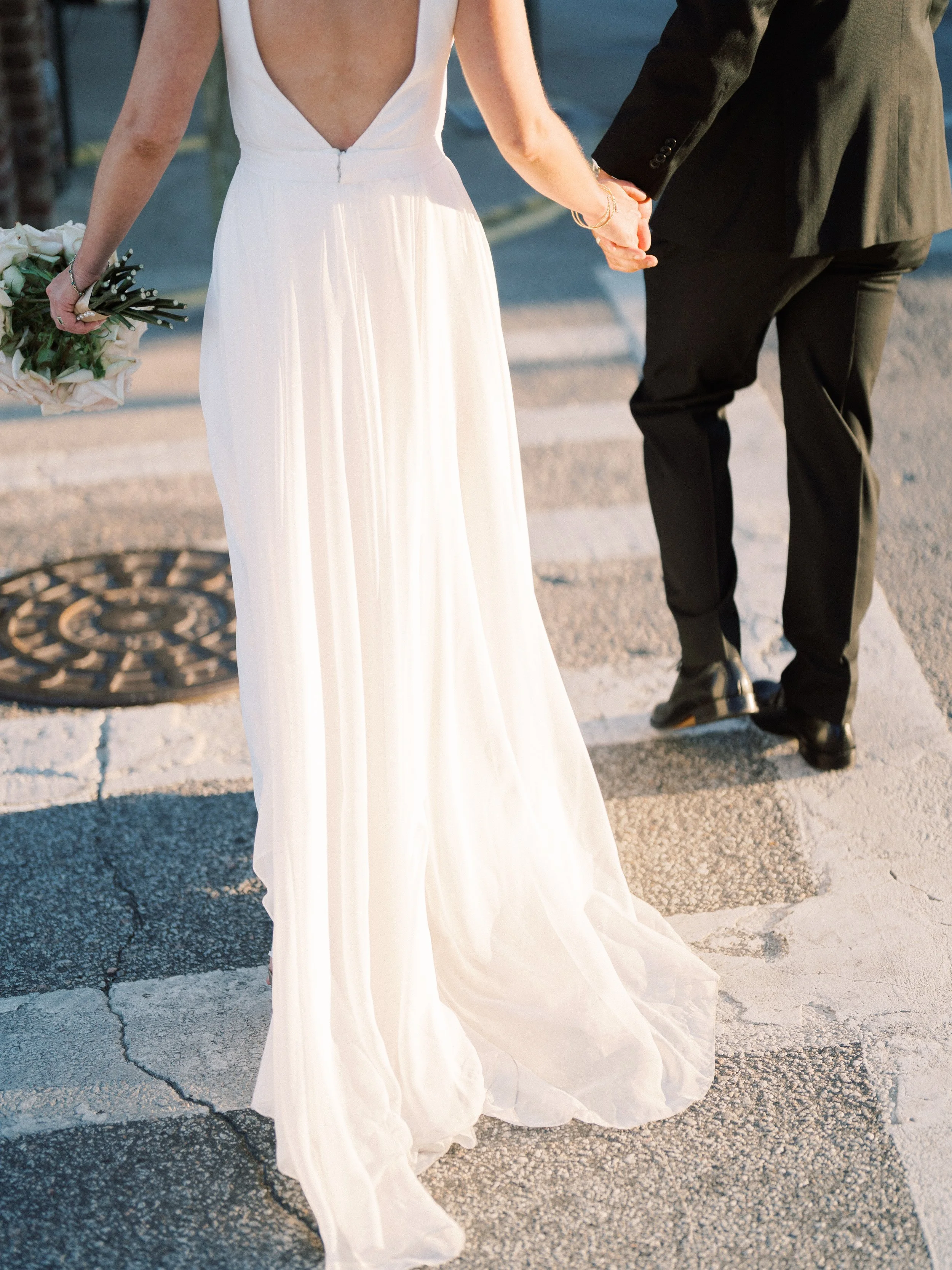 Bride and groom walking together outside The Dewberry Hotel wedding in Charleston South Carolina