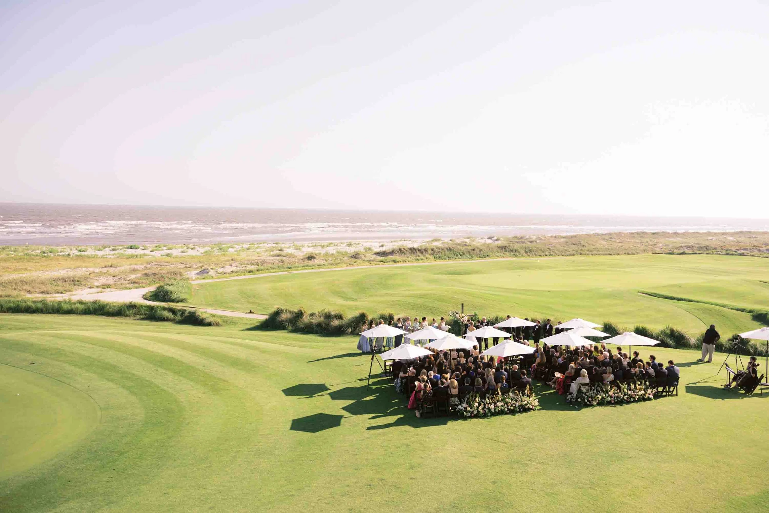 Aerial view of an outdoor wedding ceremony overlooking the ocean at the Ocean Course on Kiawah Island