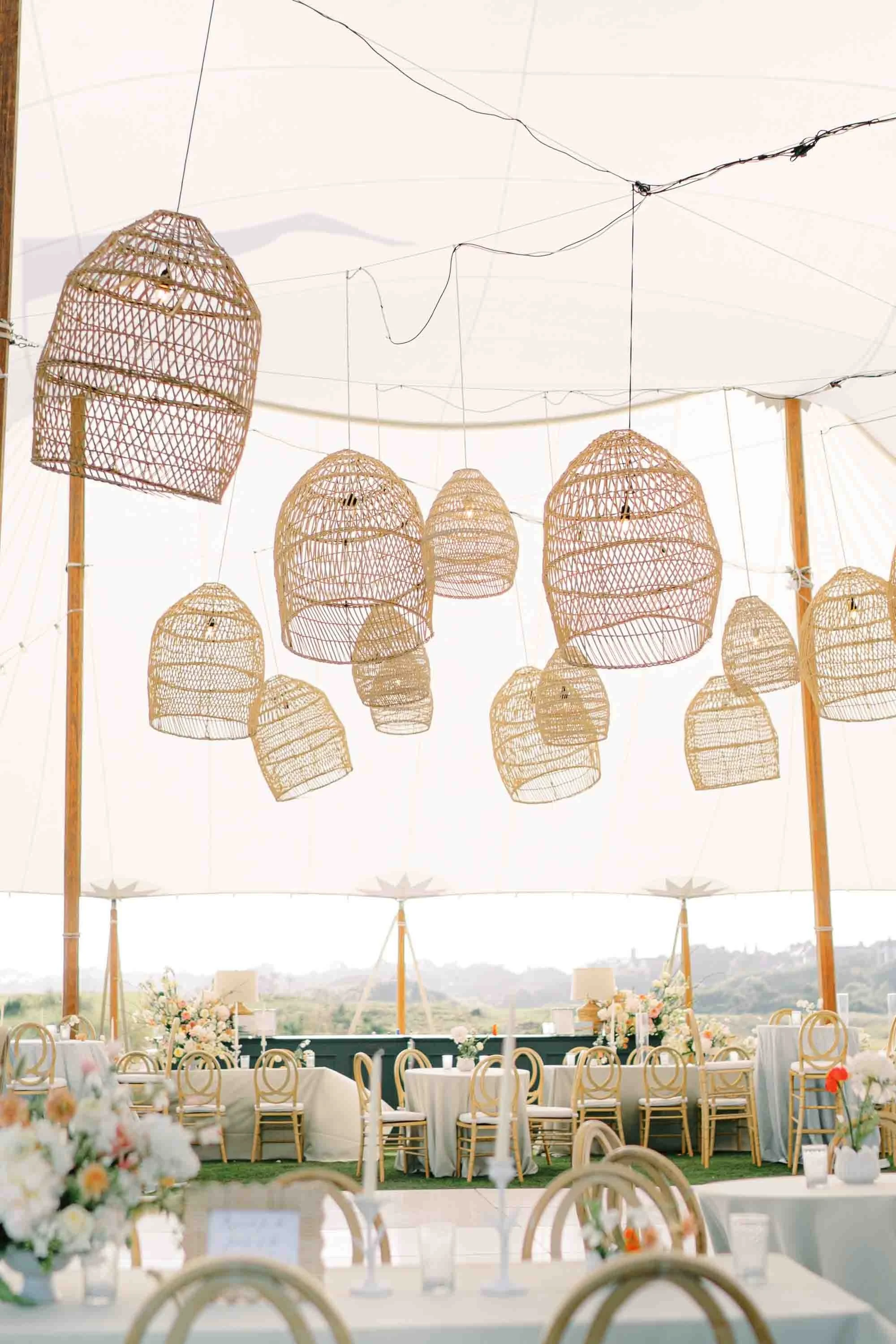 Elegant wedding reception tent with woven lantern lighting and floral tablescapes at Kiawah Island