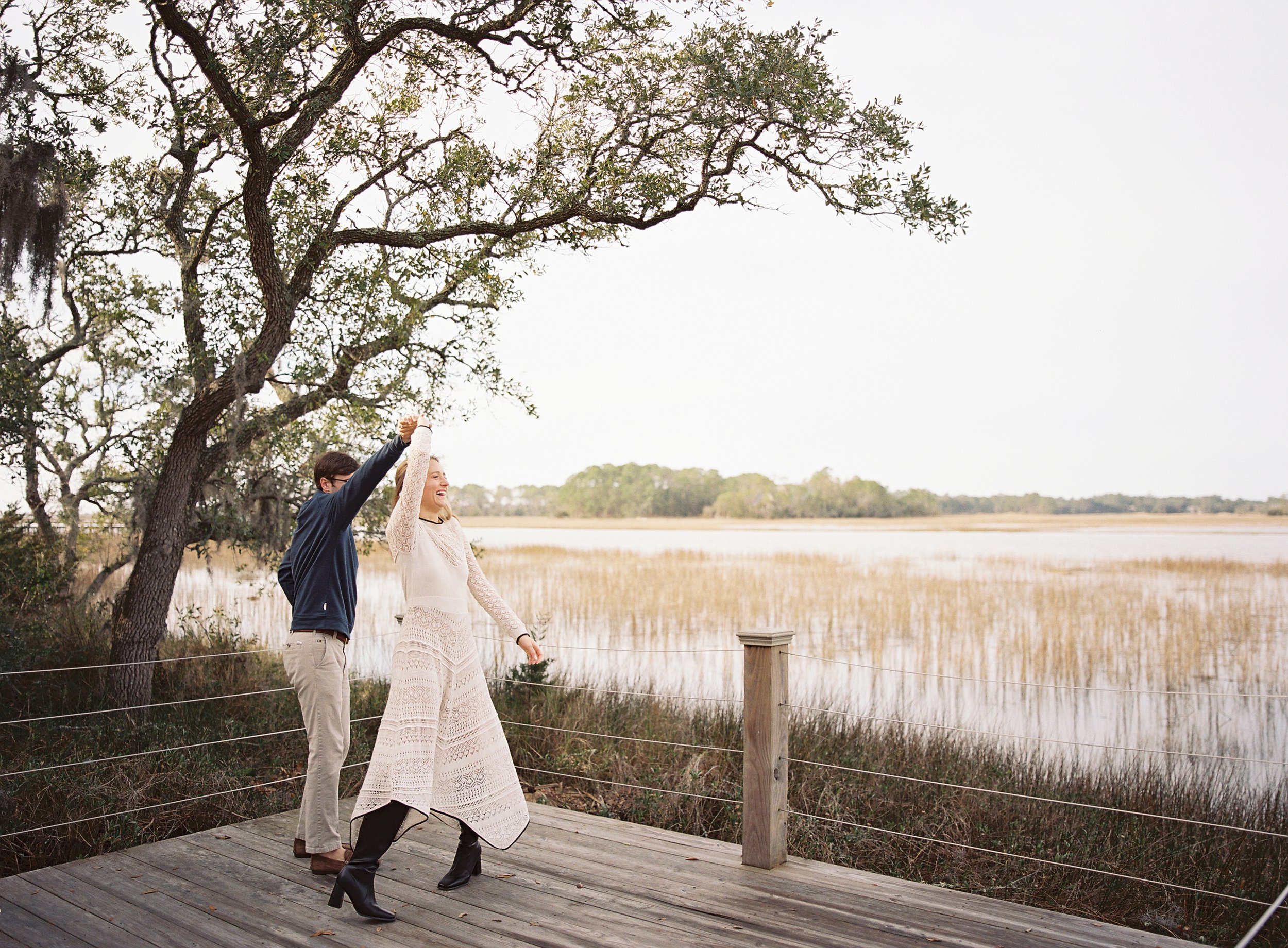 Newly Engaged couple dancing on a dock at Mingo Point during their engagement session on Kiawah Island