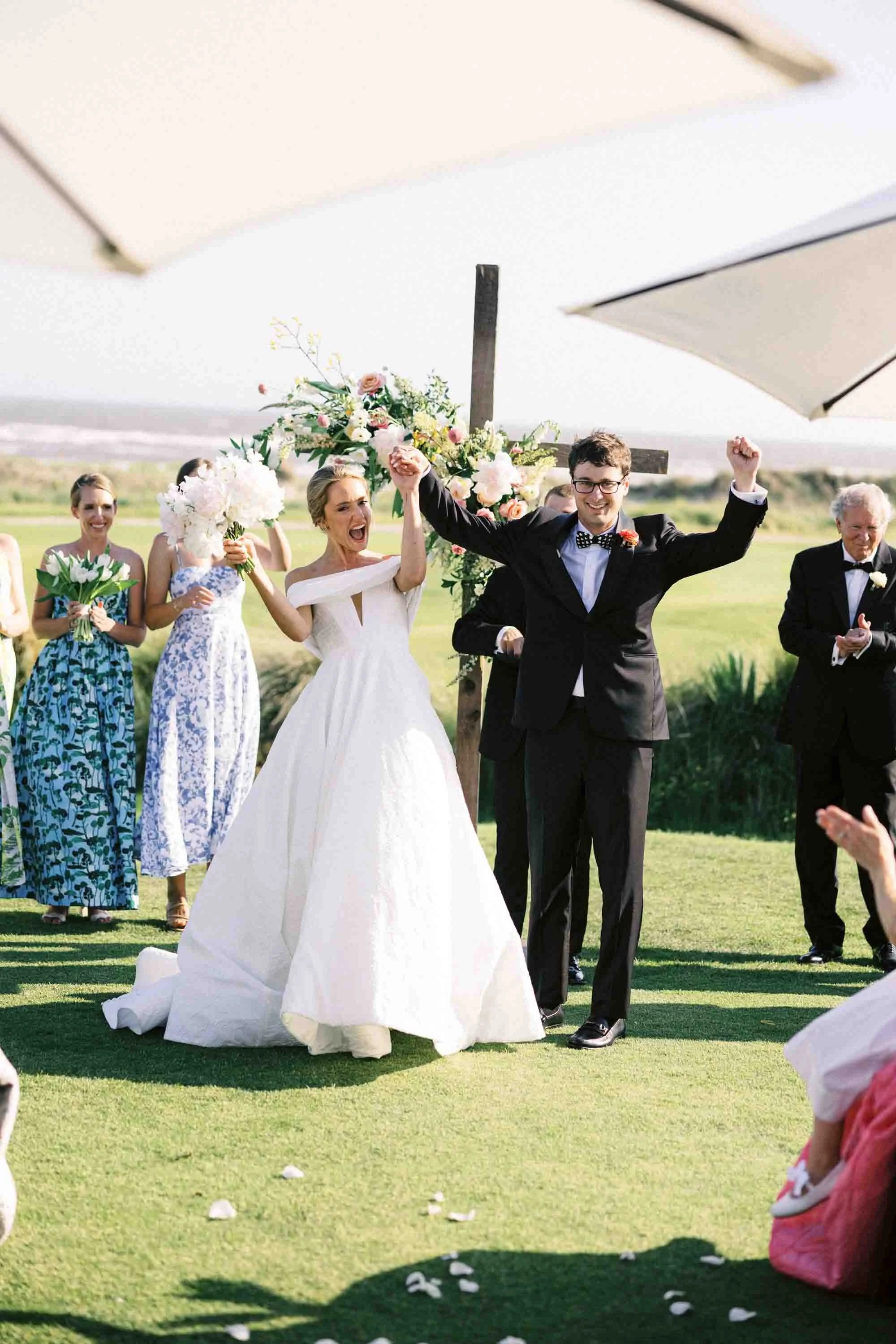 Bride and groom celebrating as they walk back down the aisle after their ceremony at Kiawah Island