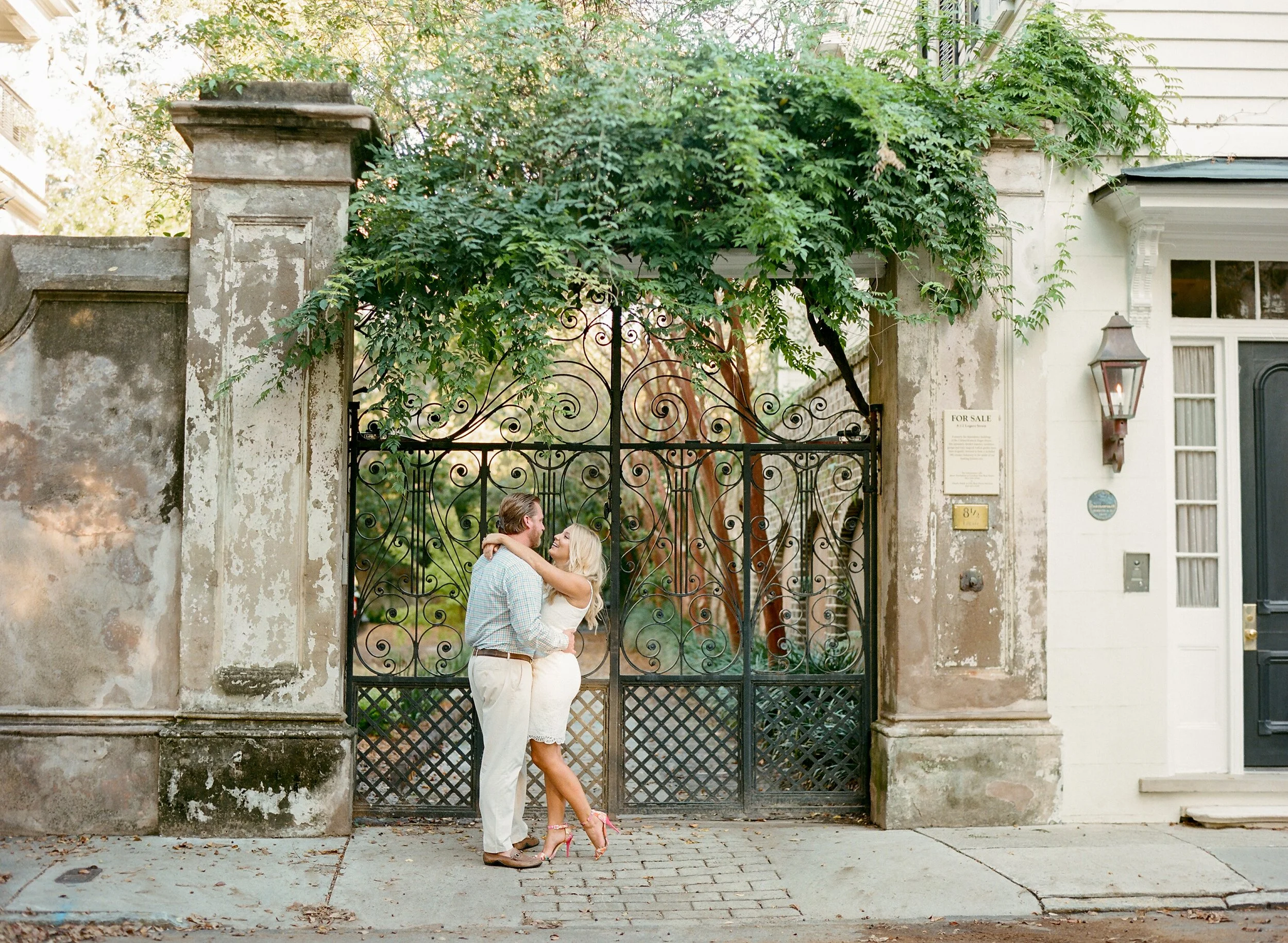 engagement photos at the Battery in Charleston with couple by historic iron gate and ivy wall