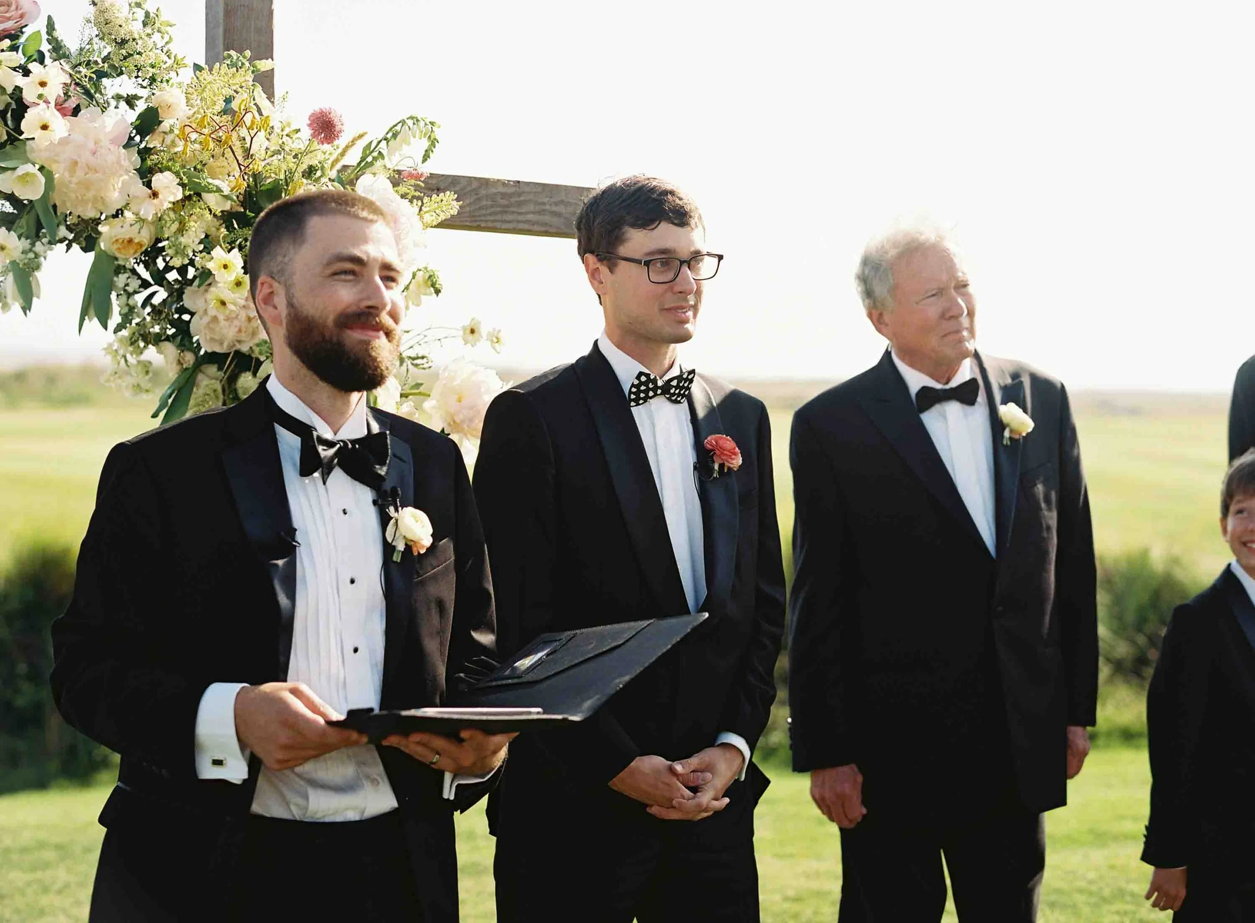 Groom standing with family and officiant during the ceremony at the Ocean Course on Kiawah Island
