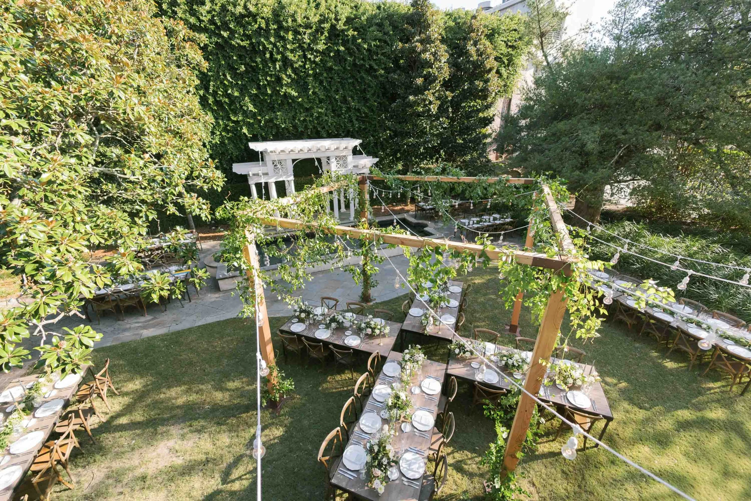 outdoor reception setup with ivy covered wooden structure at a William Aiken House Wedding