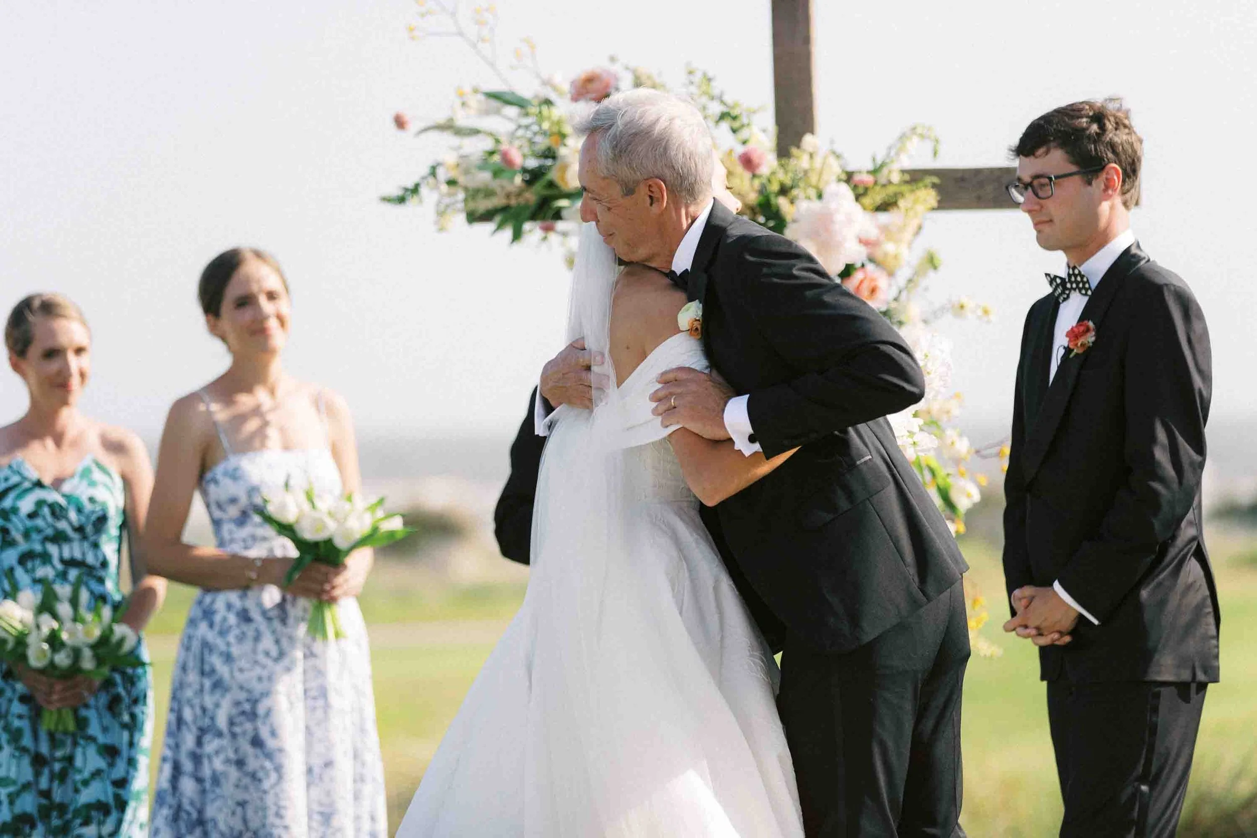 Bride hugging her father during the ceremony at an outdoor Kiawah Island wedding