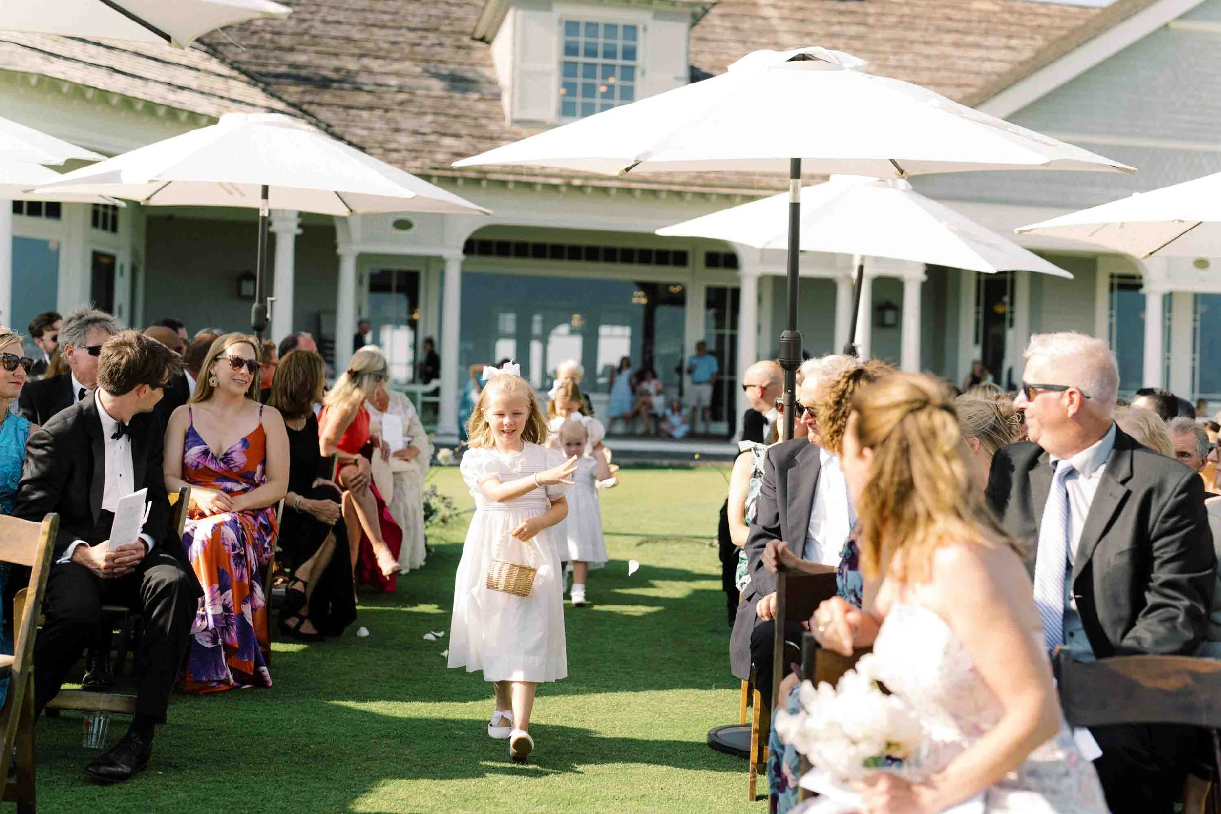 Flower girl walking down the aisle during an outdoor wedding ceremony at Kiawah Island