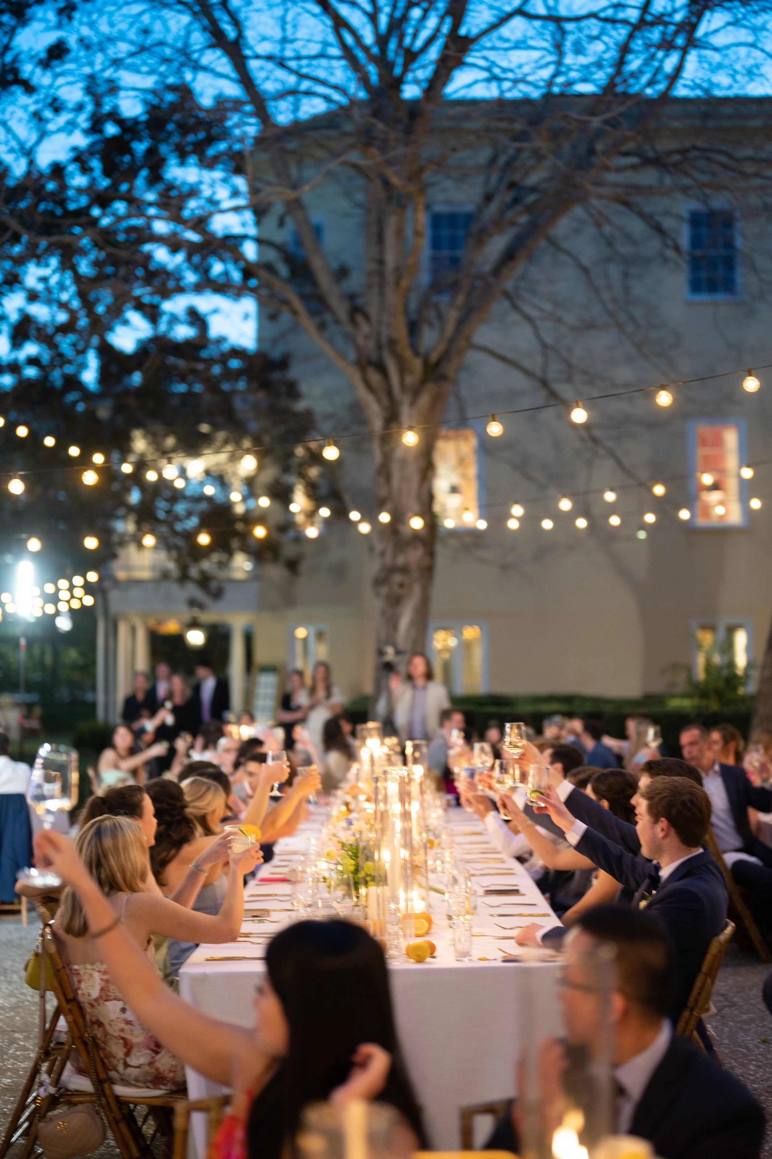 Wedding guests seated under twinkle lights at William Aiken House reception in Charleston South Carolina