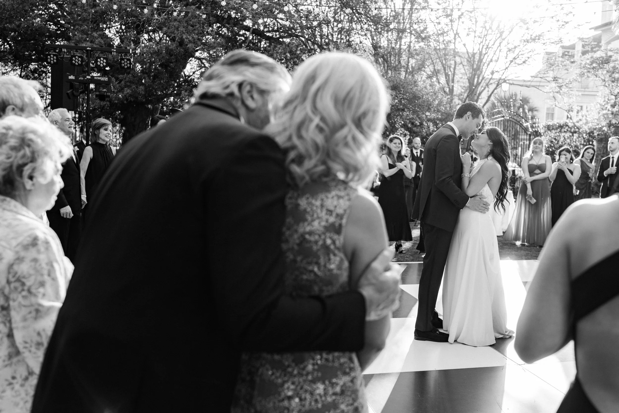 Emotional moment of parents watching first dance of bride and groom,  photographed by Charleston based fine art wedding photographer, Lauren Jonas