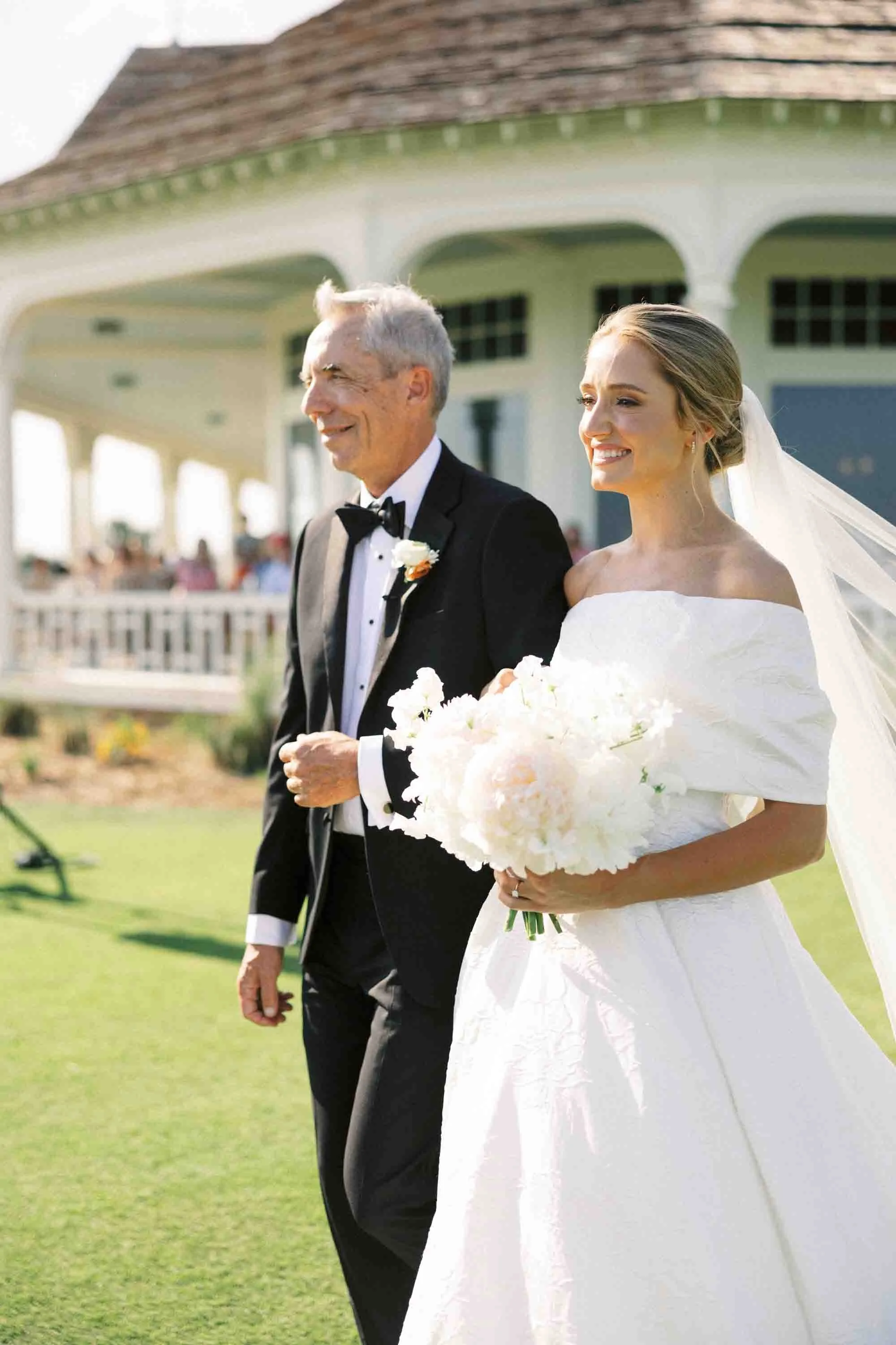 Bride walking down the aisle with her father during an outdoor ceremony at Kiawah Island