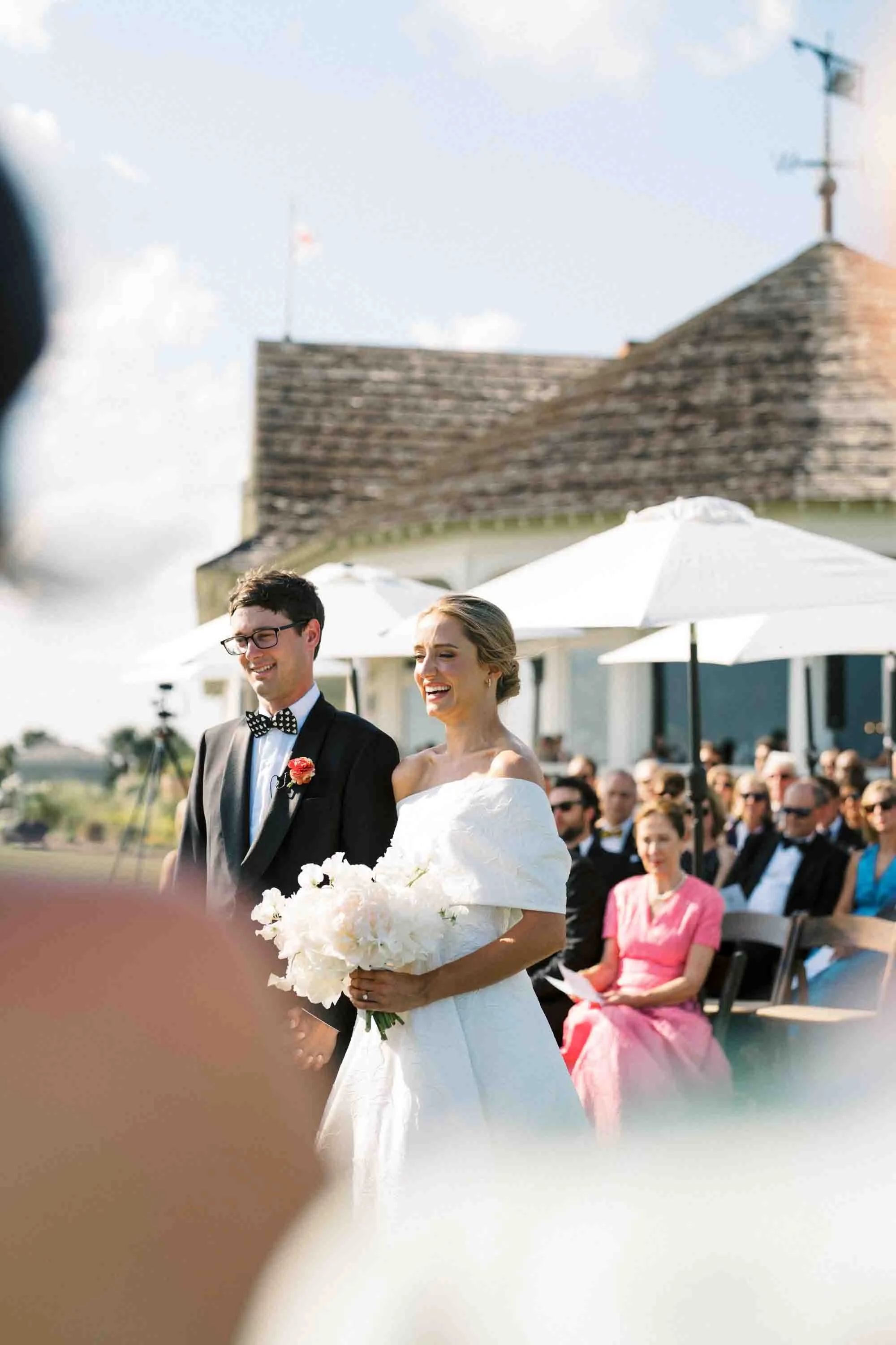 Bride and groom smiling during their outdoor wedding ceremony at Kiawah Island