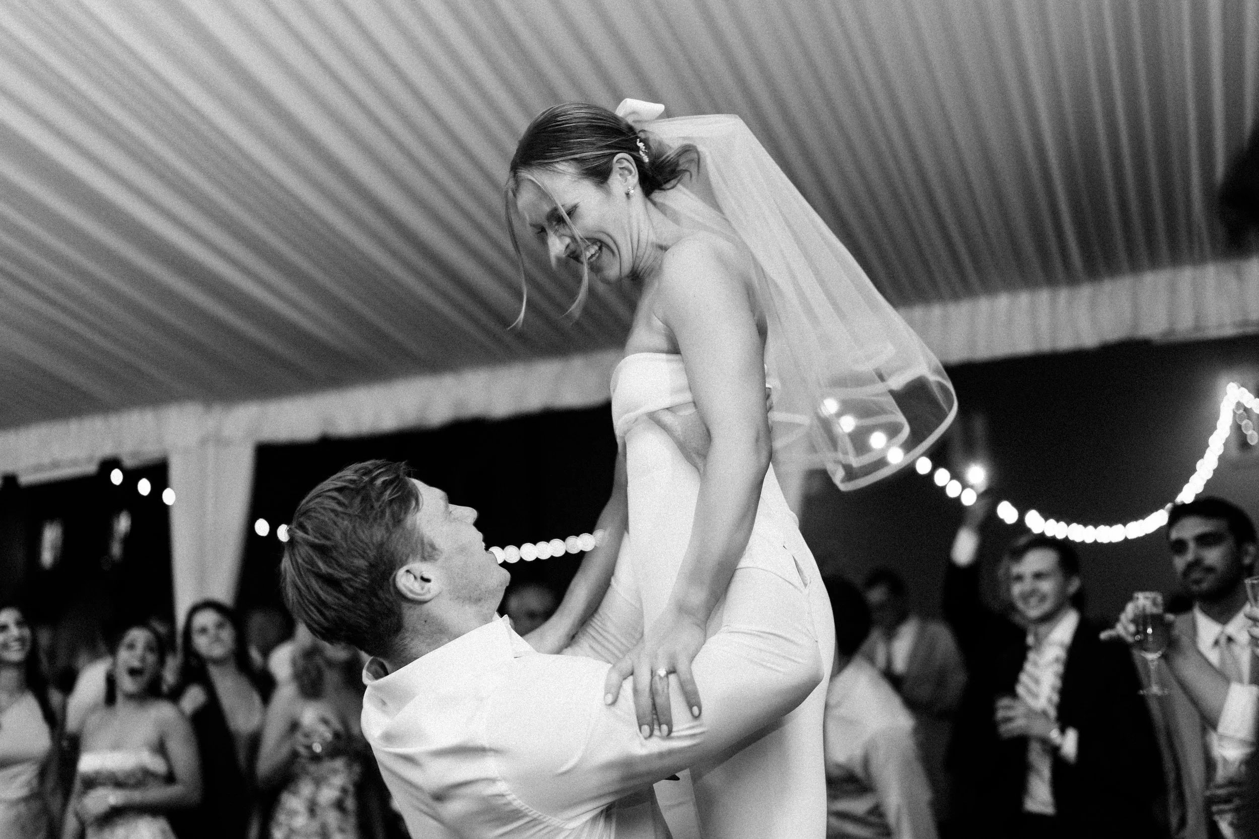 Bride being lifted during wedding reception at the William Aiken House