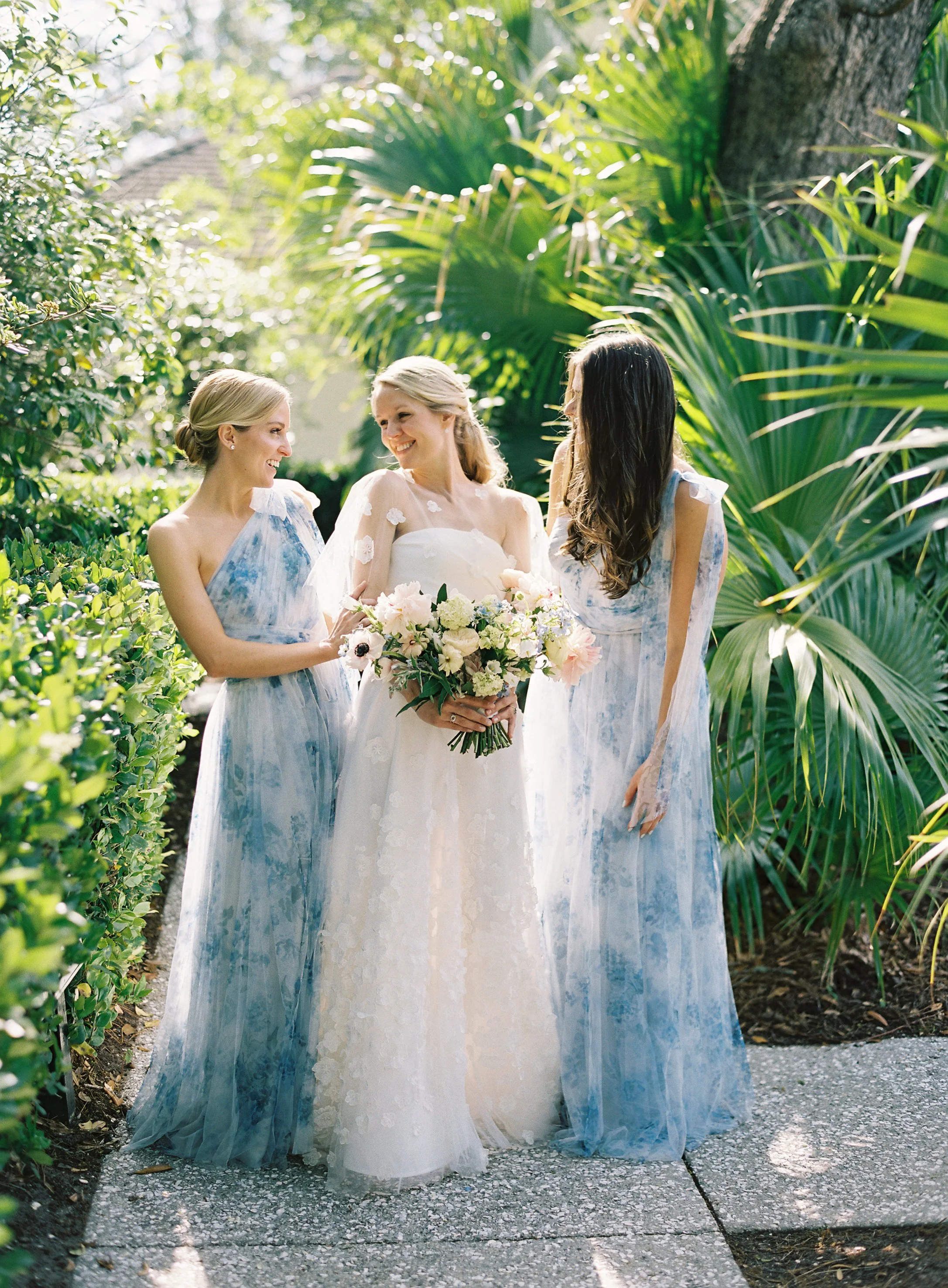 Bride with bridesmaids in blue gowns at River House wedding in Charleston, South Carolina