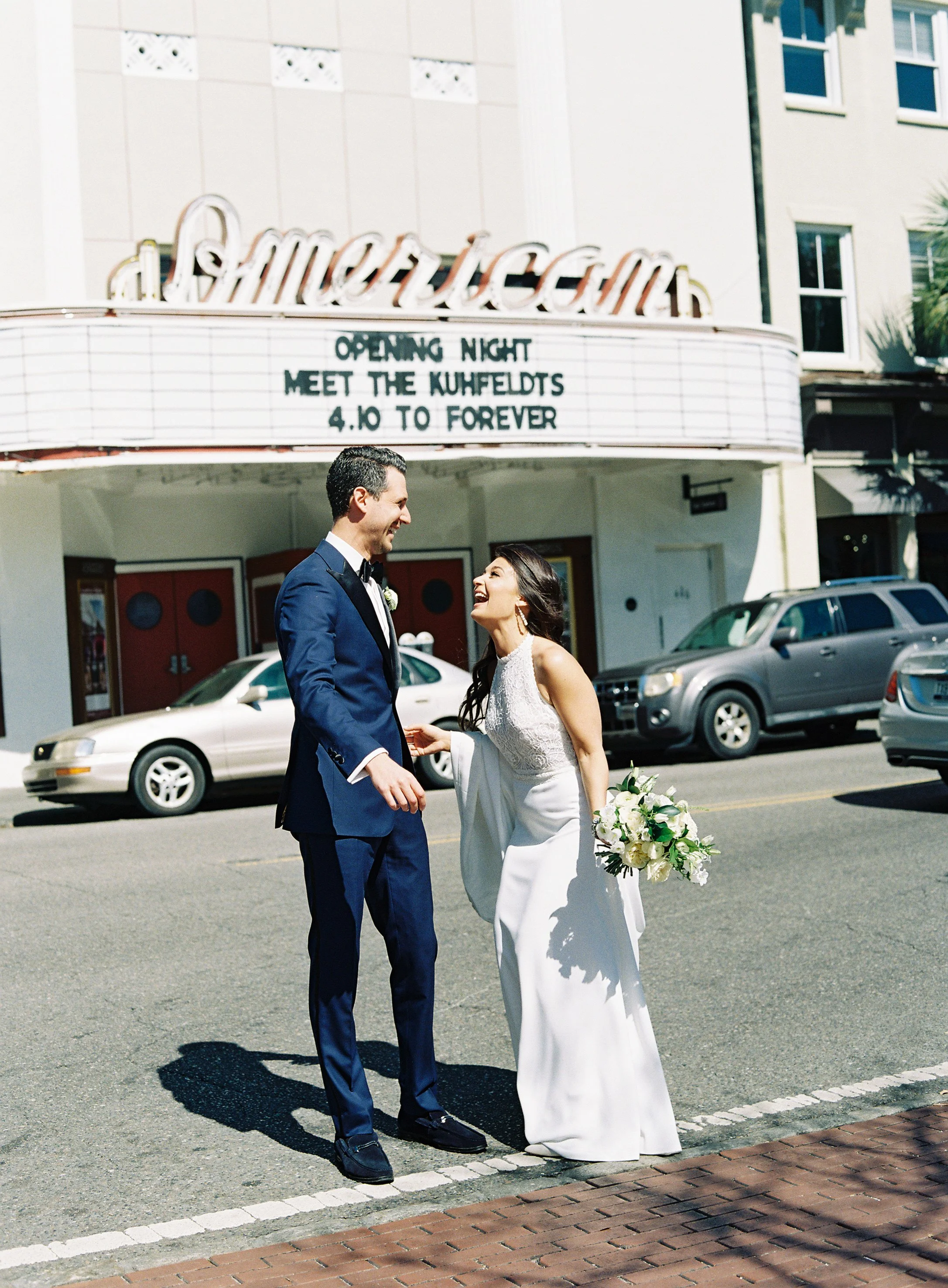 Bride and groom portraits in front of the American Theater marquee during their William Aiken House wedding in Charleston