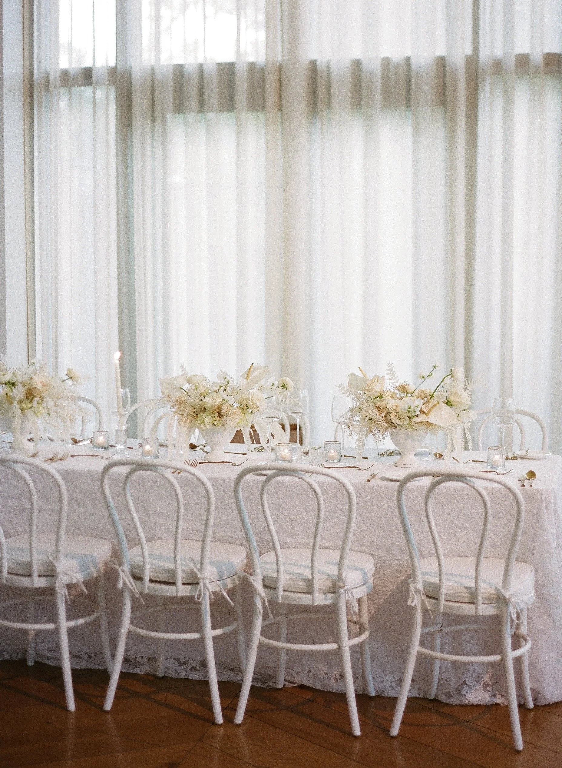 All white wedding reception in the ballroom at The Dewberry in Charleston, South Carolina