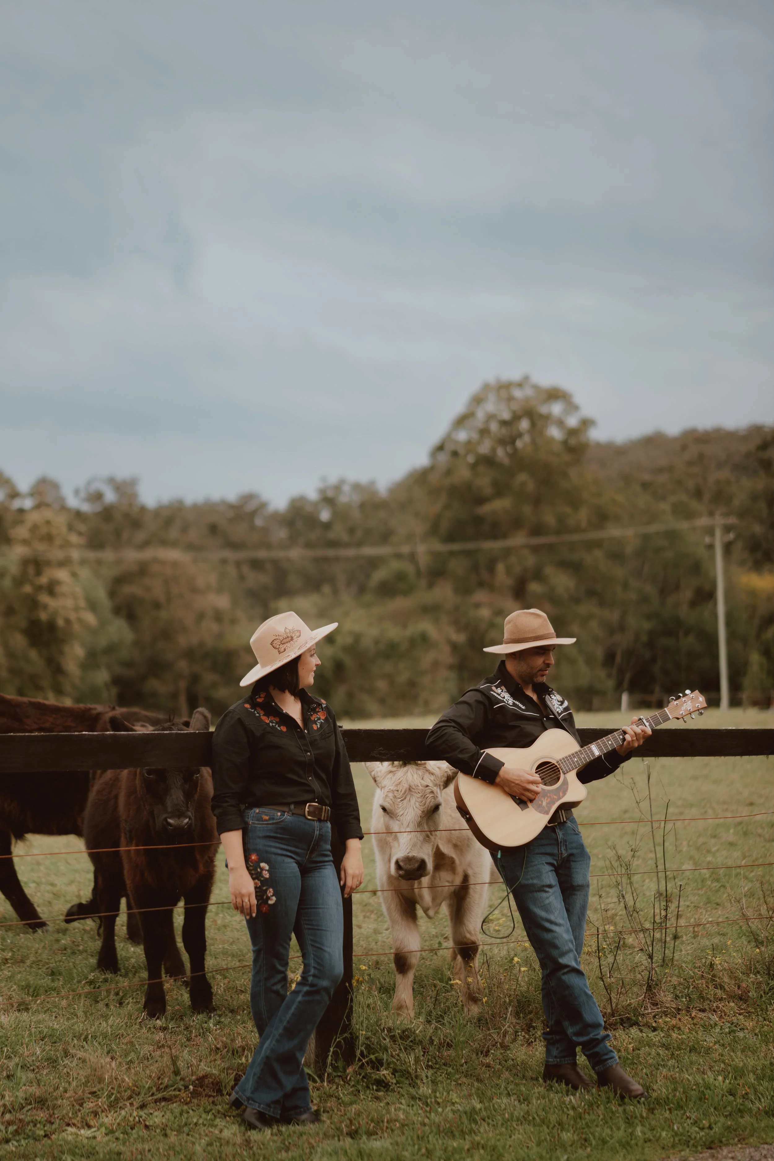A singer and guitarist standing with an acoustic guitar