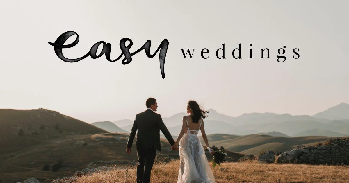 A bride and groom walking hand in hand in a scenic outdoor landscape with mountains in the background, en route to their wedding, with a text overlay that says "easy weddings".