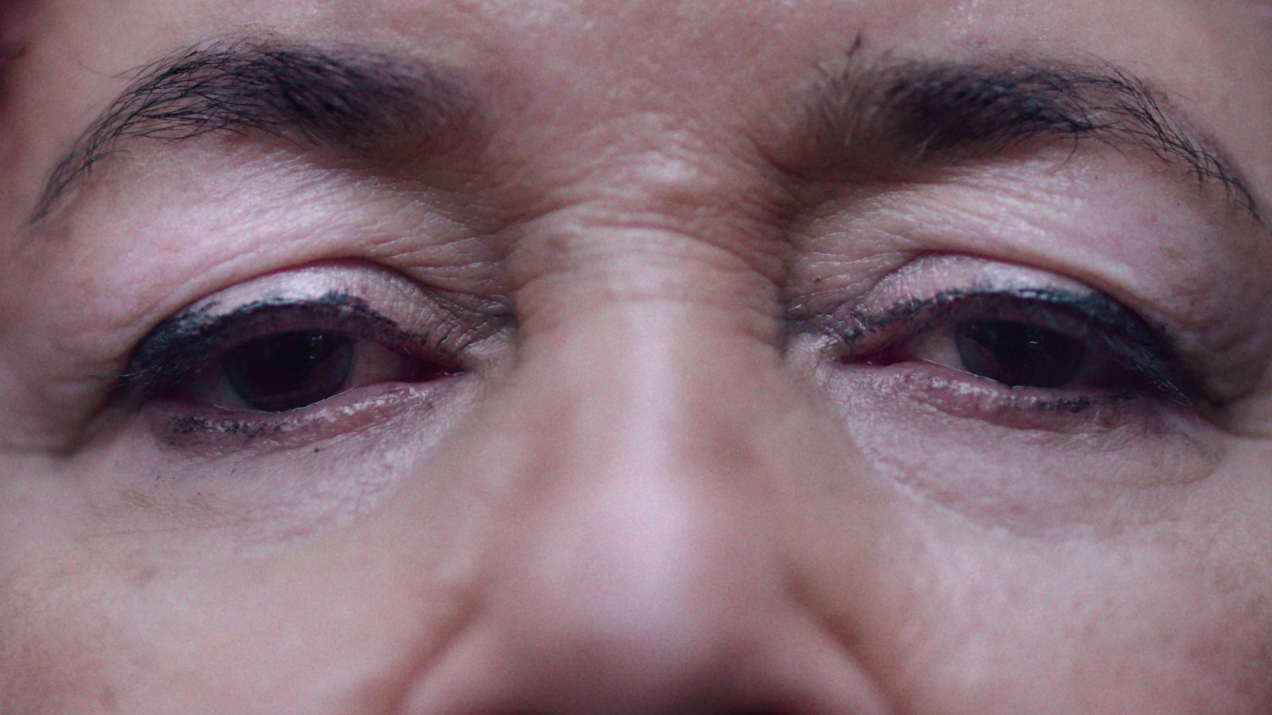 A woman with dark eyes stares into camera, GRETA