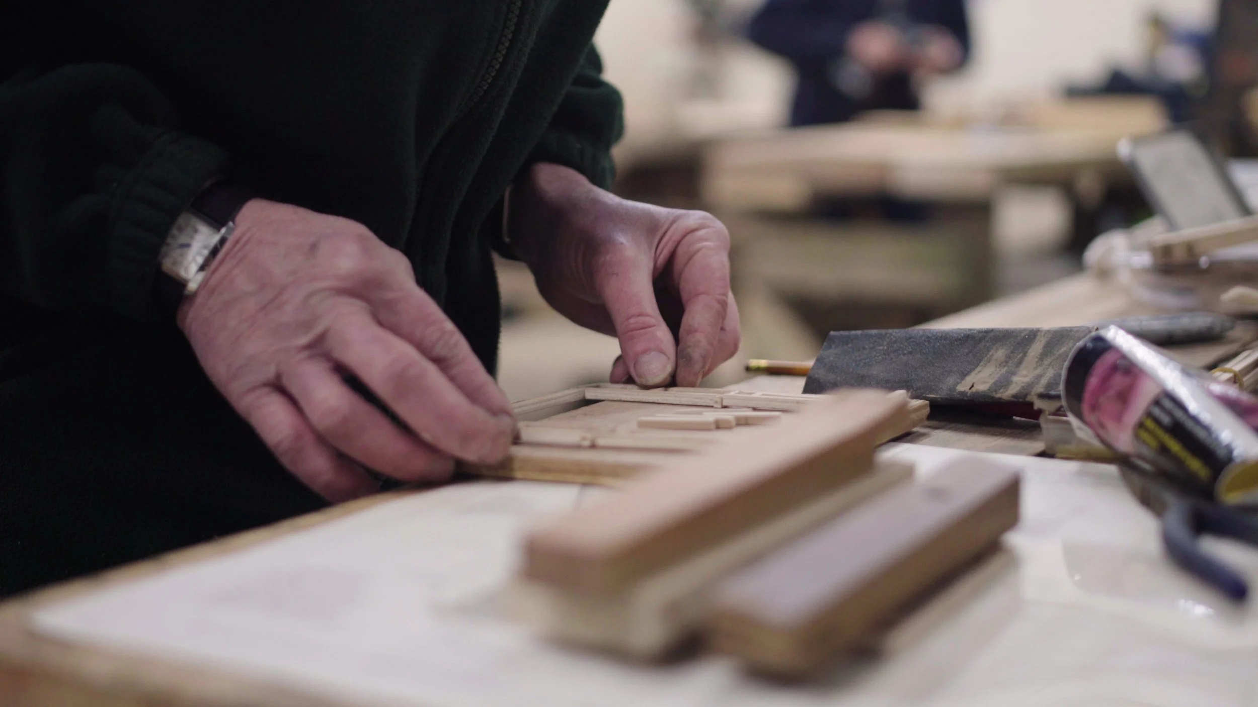 A pair of hands works on a wood project, Men's Shed