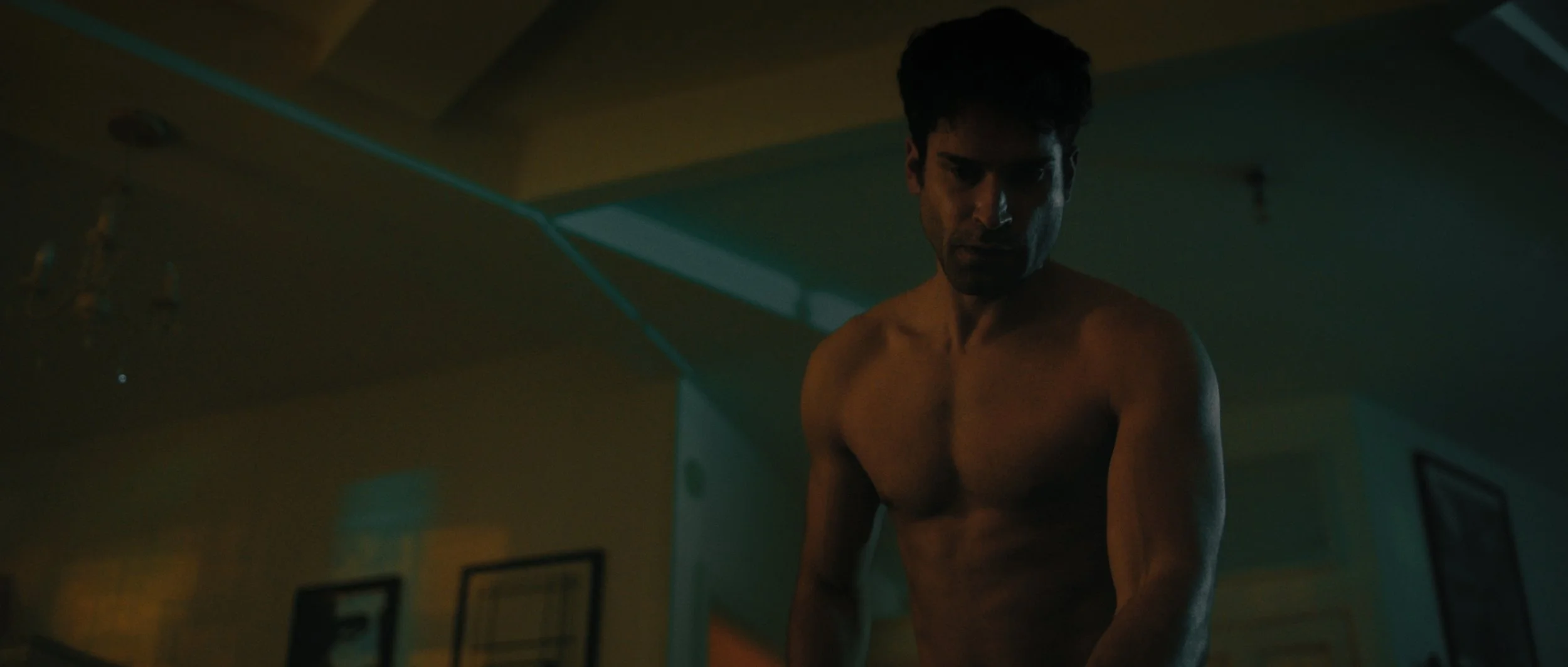 A man walks across a dark living room with orange and green lighting, Night Whispers